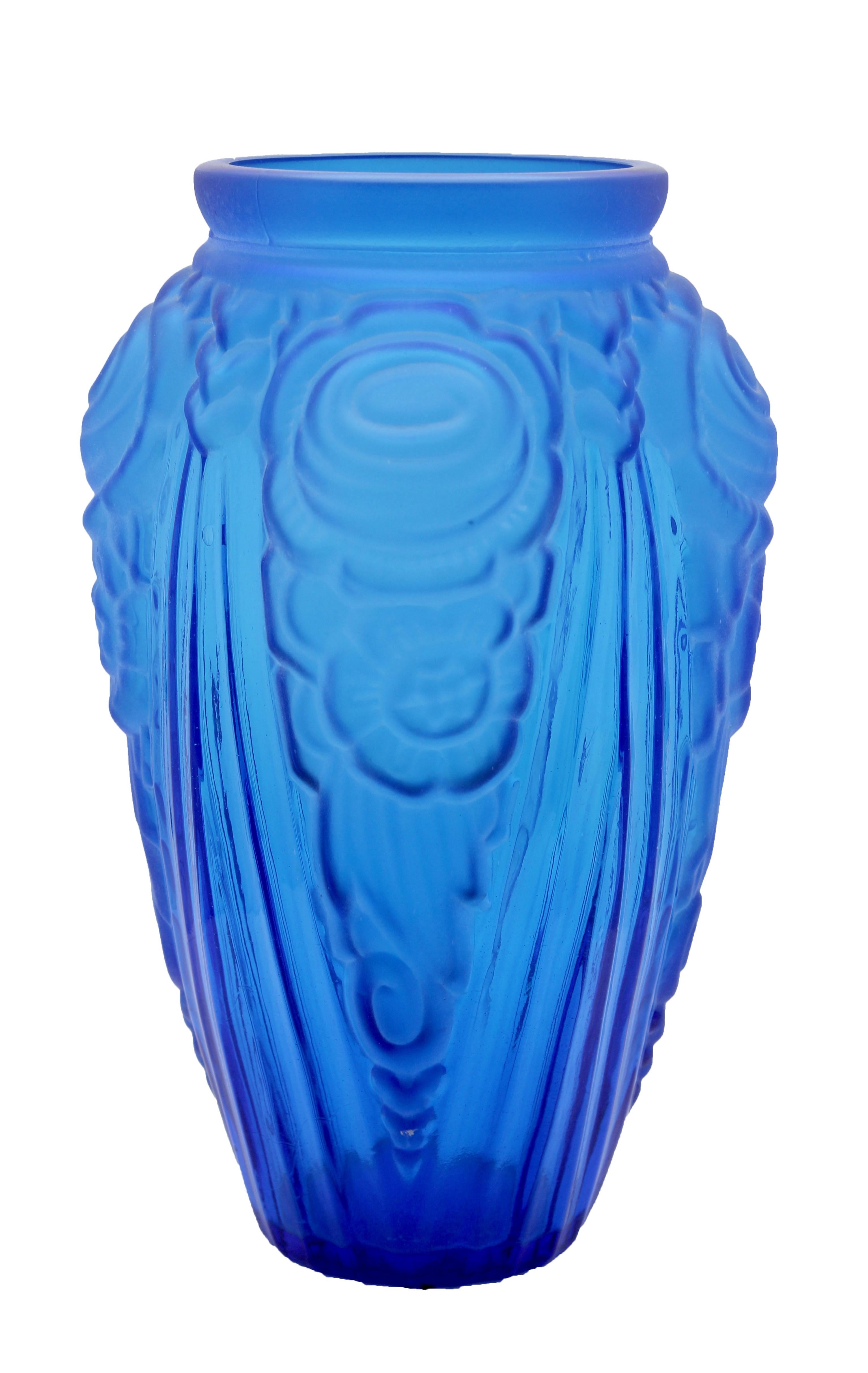 Imposant vas en verre pressé dépoli bleu de style Art Déco. Ce grand vase oppose la géométrie des lignes aux formes plus rondes des fleurs et date du début des années 1930. Il a été créé dans l'usine peu reconnue de Neiman Stolle à Vratislava:: en