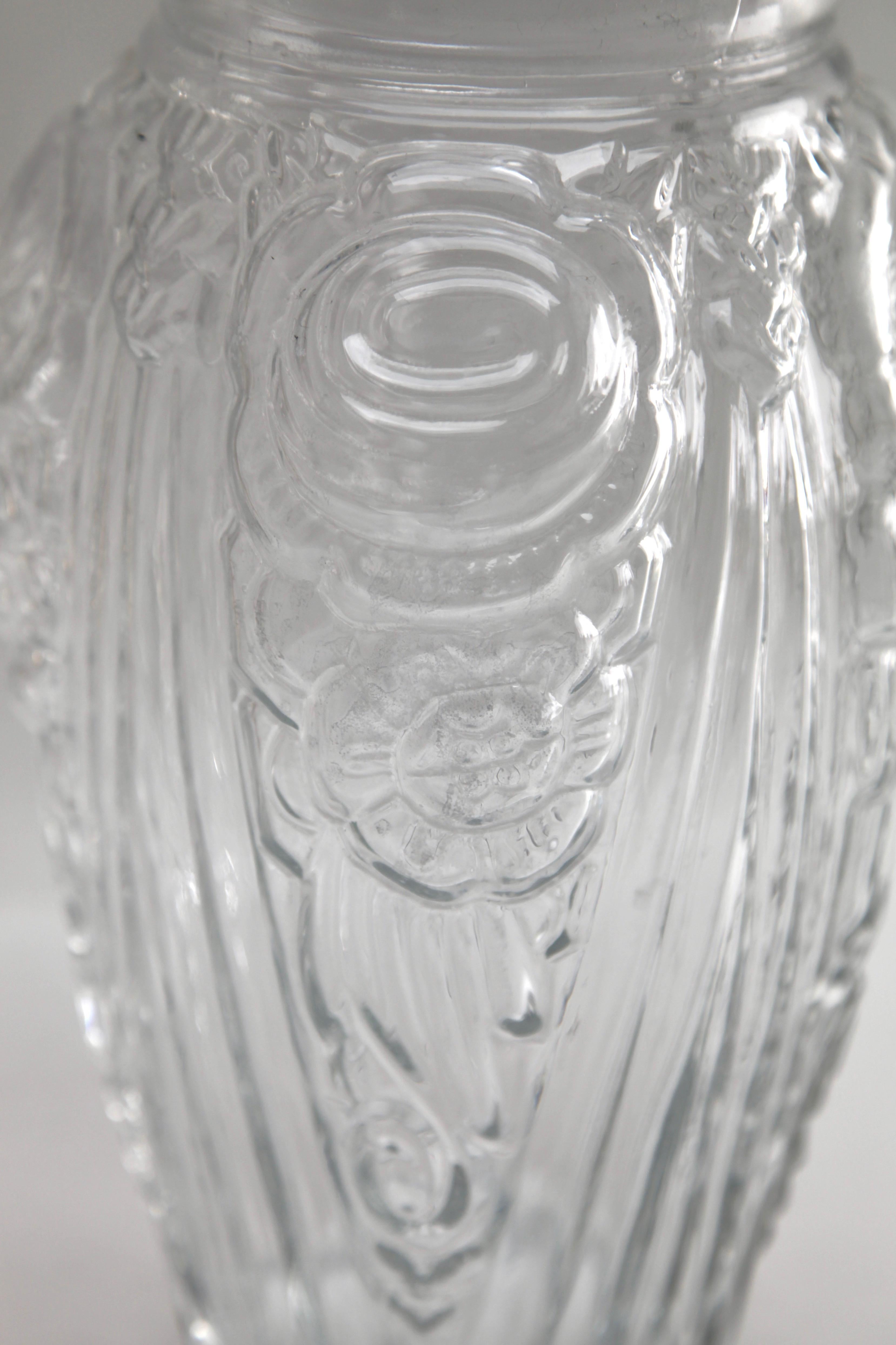 Imposante Vase aus blauem, mattiertem Pressglas im Art-Déco-Stil. Diese große Vase kontrastiert die Geometrie der Linien mit den runderen Formen der Blumen und stammt aus den frühen 1930er Jahren. Sie wurde in der wenig bekannten Fabrik von Neiman