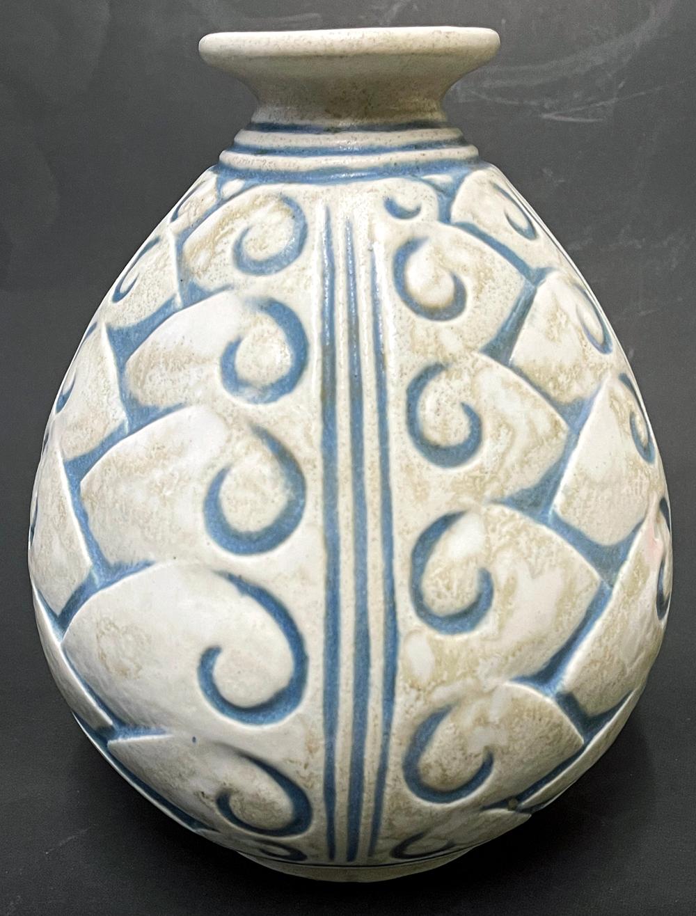 Unusual and striking, this Art Deco vase with stylized foliate forms is glazed in rich, subdued blues and grays, with a mottled effect not unlike the interior of seashells. The vase was produced by Joseph and Pierre Mougin, who were closely