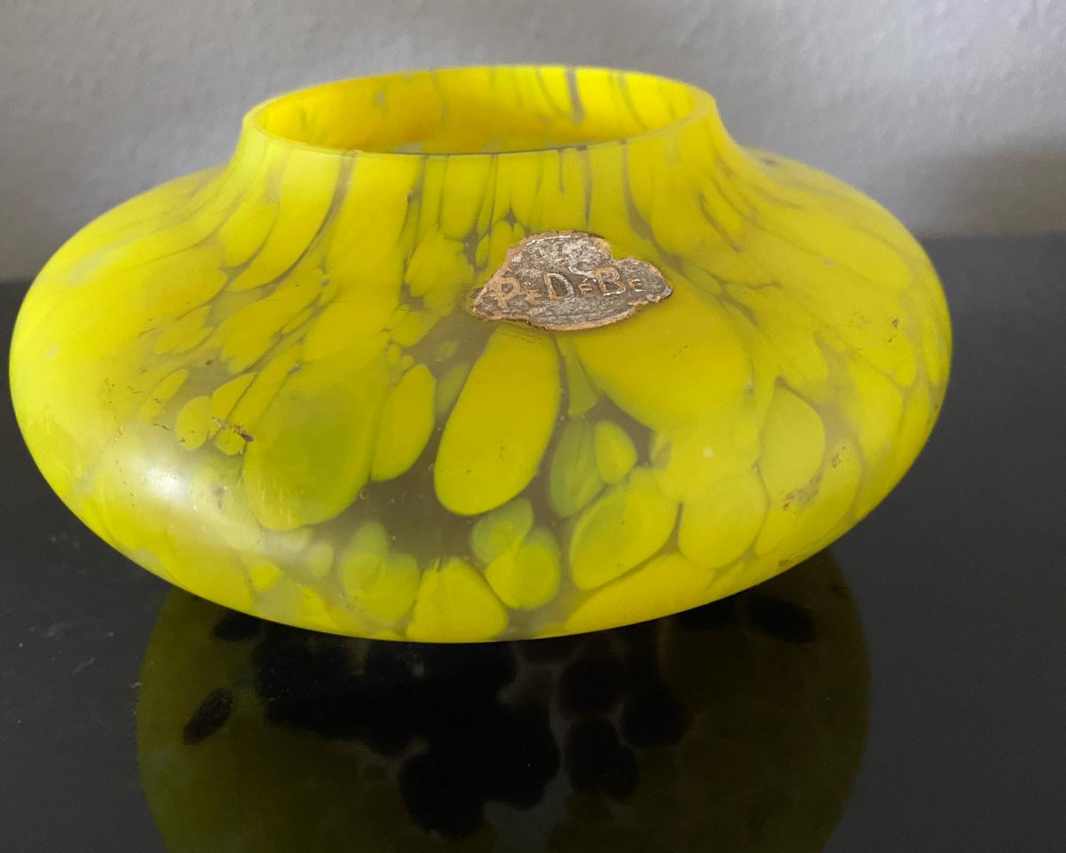 Beautiful colored Art Deco vase. Yellow 'stains' on top and brown 'stains' on the bottom. Nice size vase for one flower, but also very attractive without flowers.
The vase has a sticker of the maker PeDeBe. I did some research, but it could also