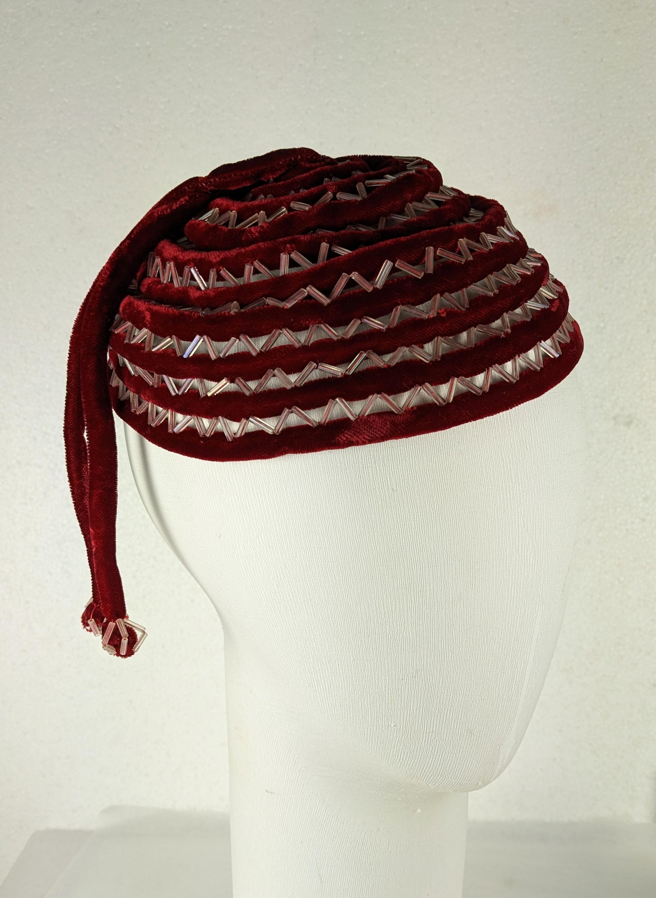 Charming Art Deco Velvet Spiral Beaded Cap from the 1920's. Burgundy bias velvet tubing is used to form a spiral with a hand stitched ladder of bugle beads connecting the 2 materials. 
Ingenious construction. 1930's USA or France. 
Height 3.5