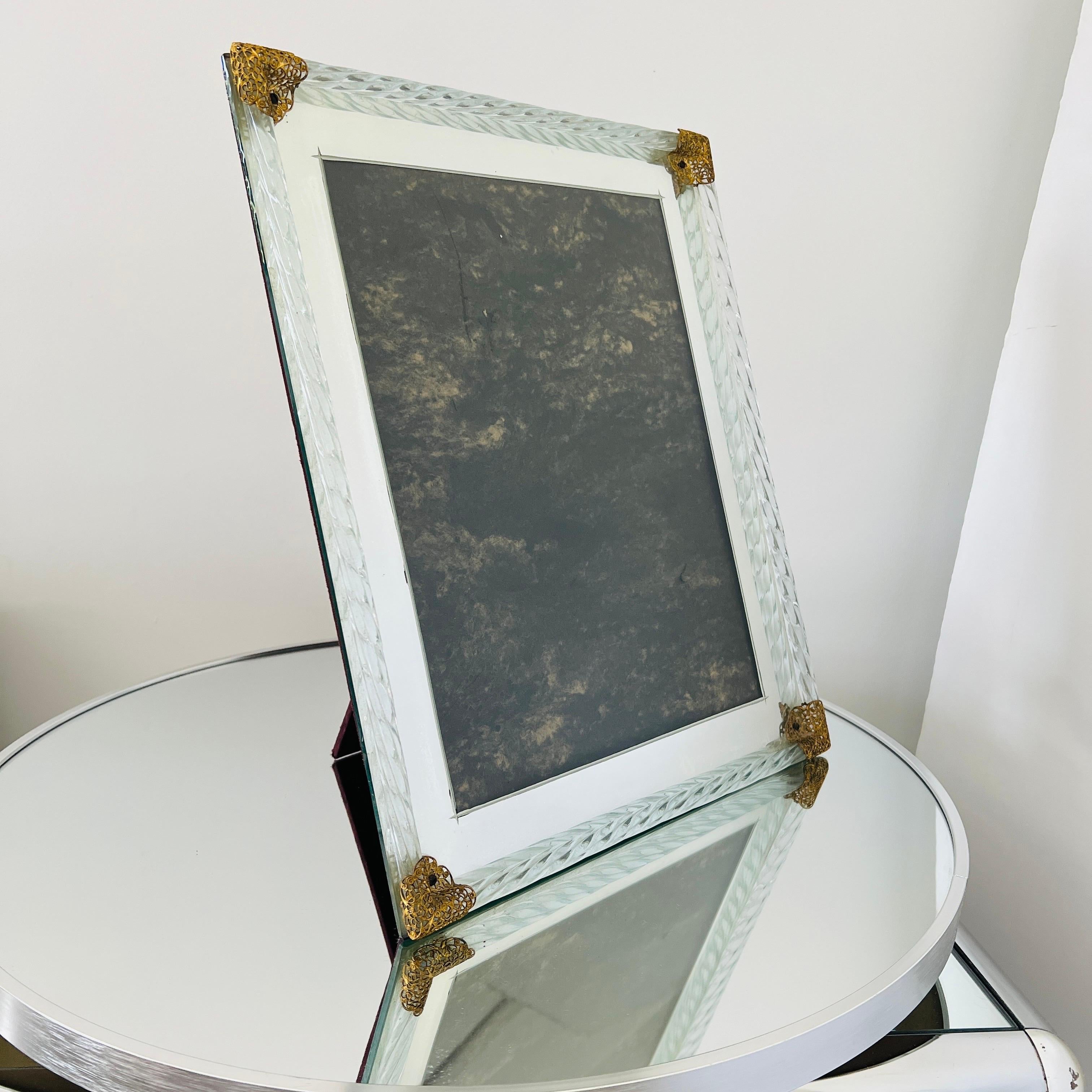 Großer verspiegelter Art-Déco-Bilderrahmen mit Seilrändern aus venezianischem Murano-Glas.  Der Rahmen hat schöne filigrane Akzente aus Goldmetall in Form von stilisierten Schmetterlingen.  Der Spiegel hat abgeschrägte Details und der Rahmen kann