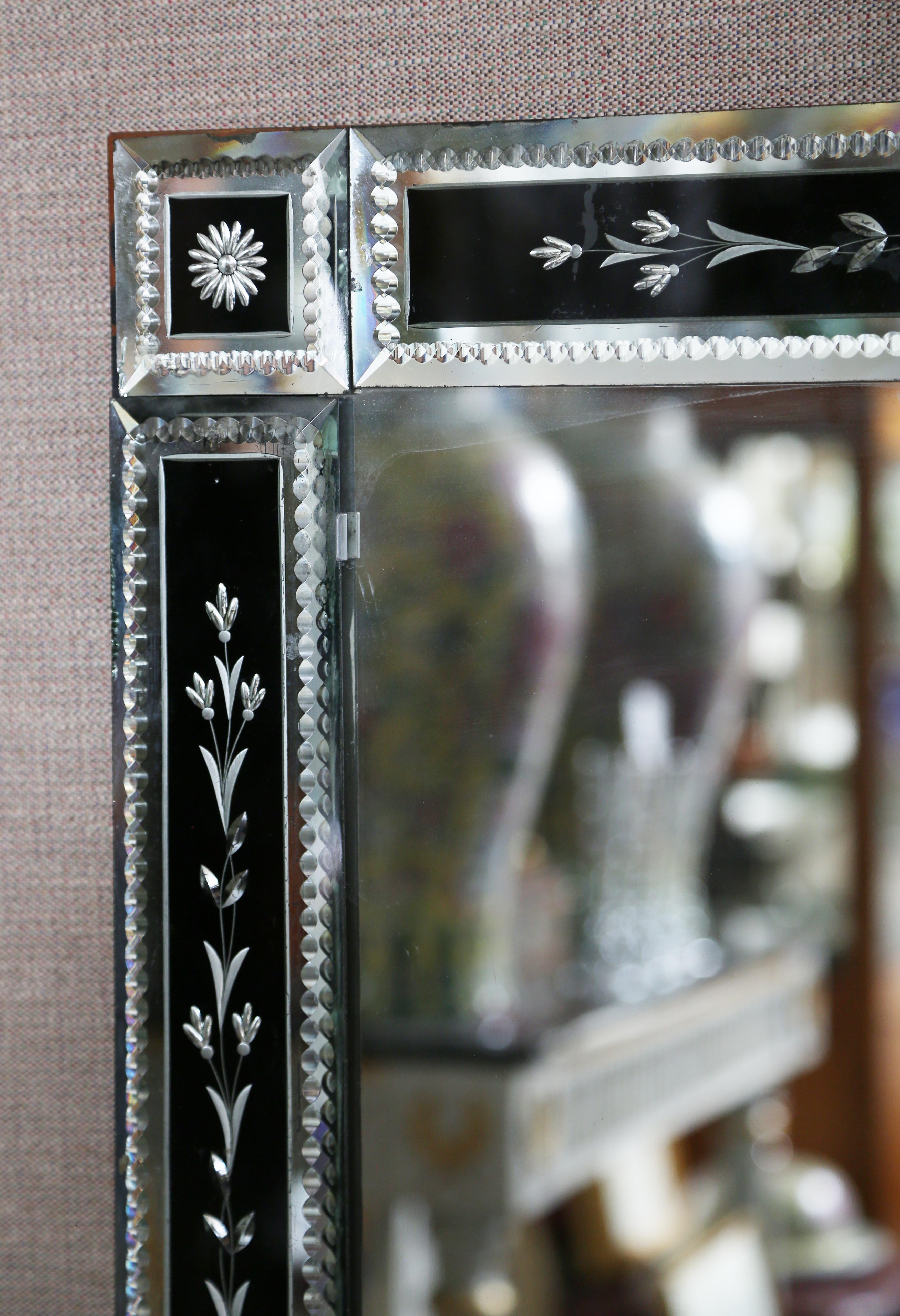 Early Art Deco Venetian glass rectangular mirror in black and clear. Each of the eight pieces making up the frame are cut, engraved, beveled and have zipper cut edges. There are several small edge flakes on the perimeter.