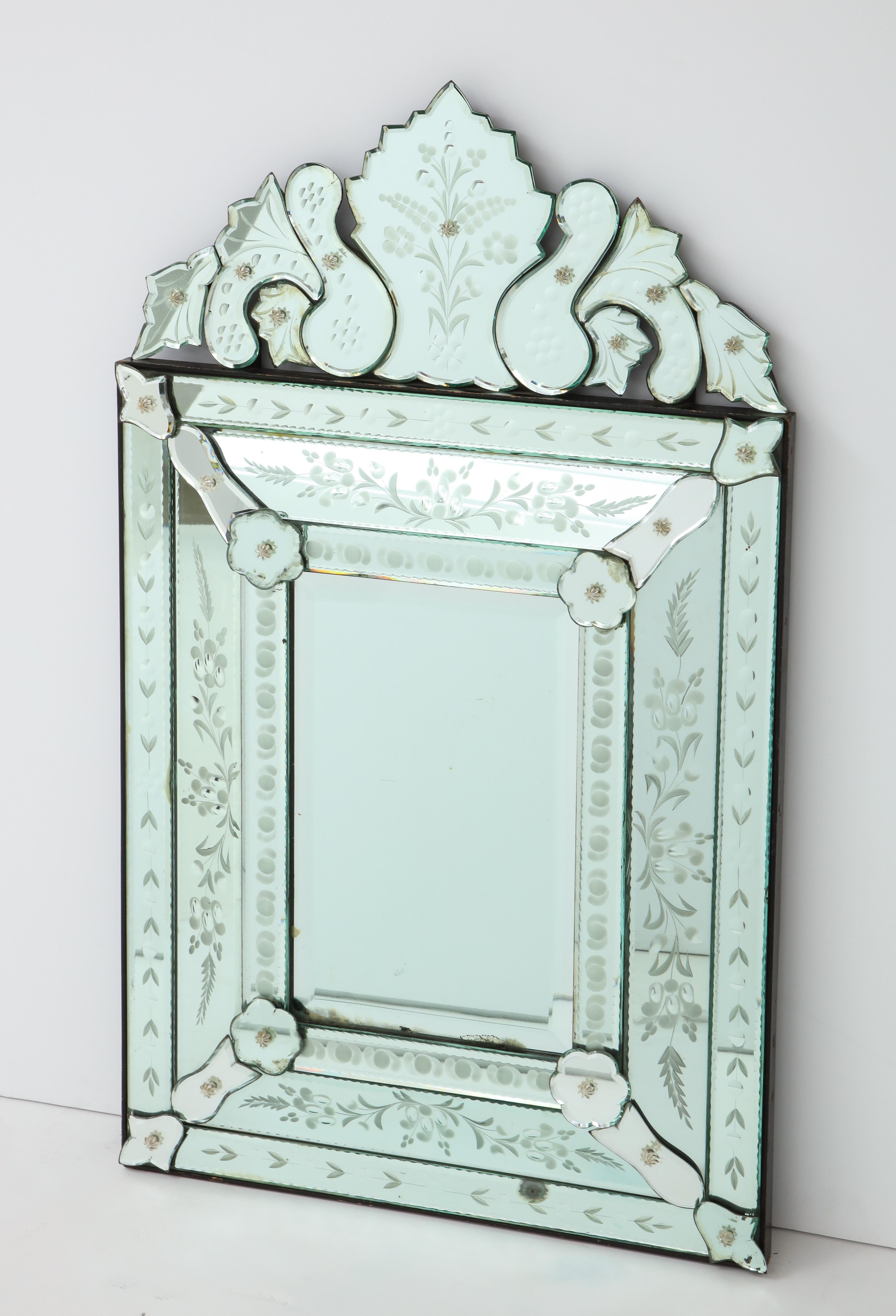 Fantastic Venetian mirror with wheel cut etched floral borders and chain beveled borders mounted on wood. All glass rosette screw covers are intact.