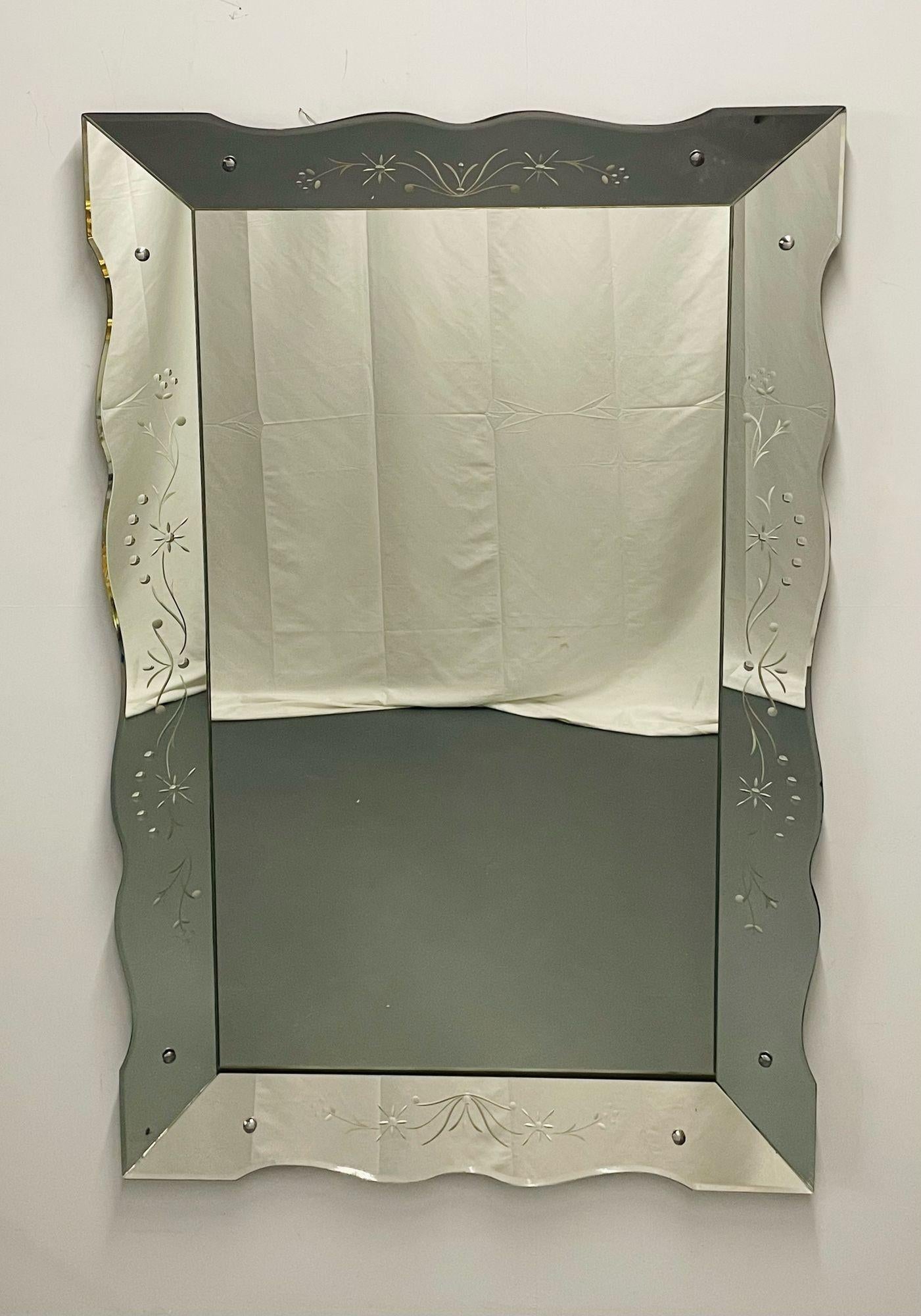 Art Deco Venetian Wall / Console Mirror, Etched Glass Floral Motif
 
A stunning Art Deco Wall or Over the Mantle Mirror having shadow box etched floral glass sides framing a center clean mirror. The mirror supported with chrome pegs on wooden