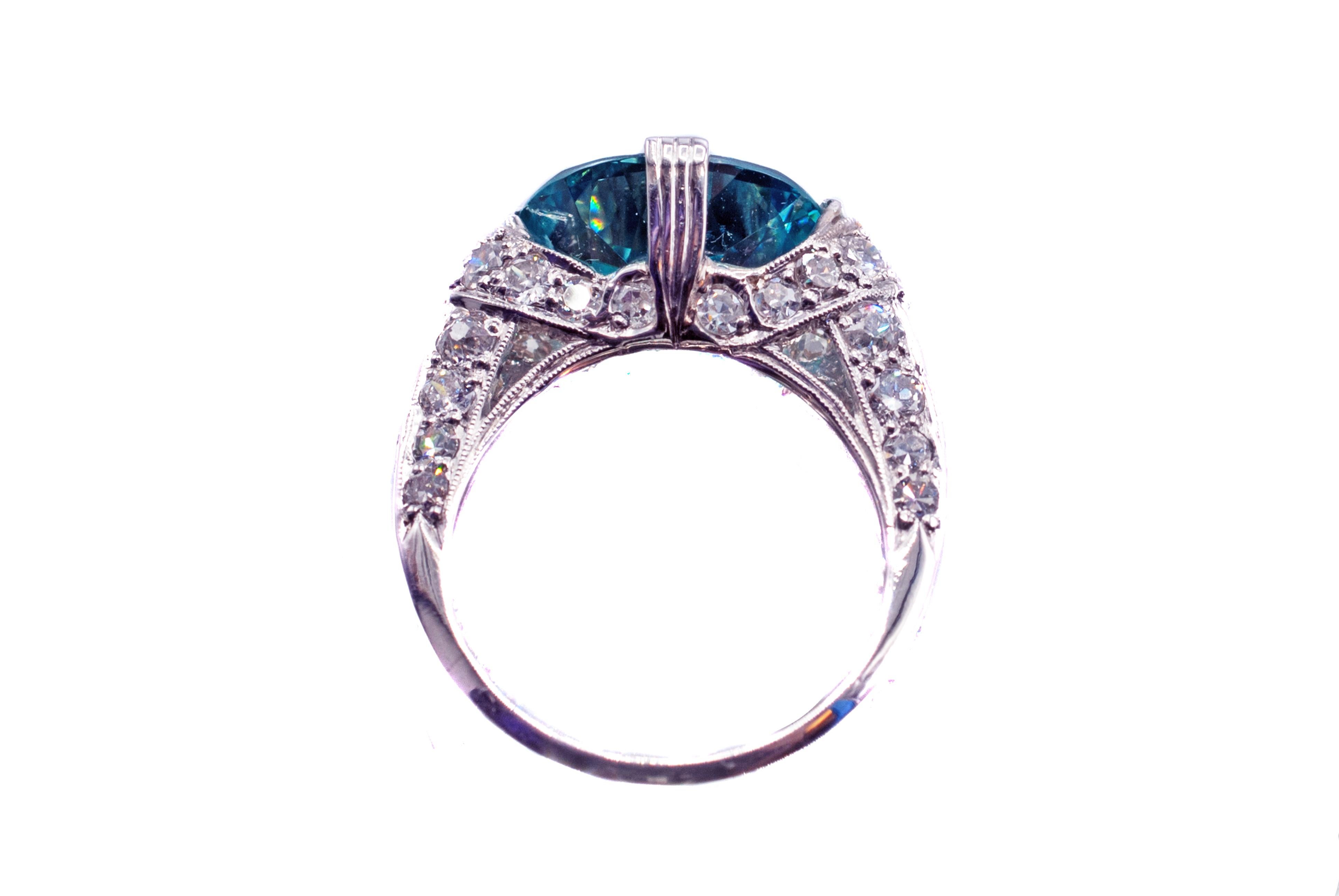 This enticing Art-Deco platinum diamond blue zircon ring from ca. 1930 features amazing craftsmanship and design. The centrally set 8.94 carat zircon is incredibly clear and displays an electric deep aqua blue color distinct to these unique
