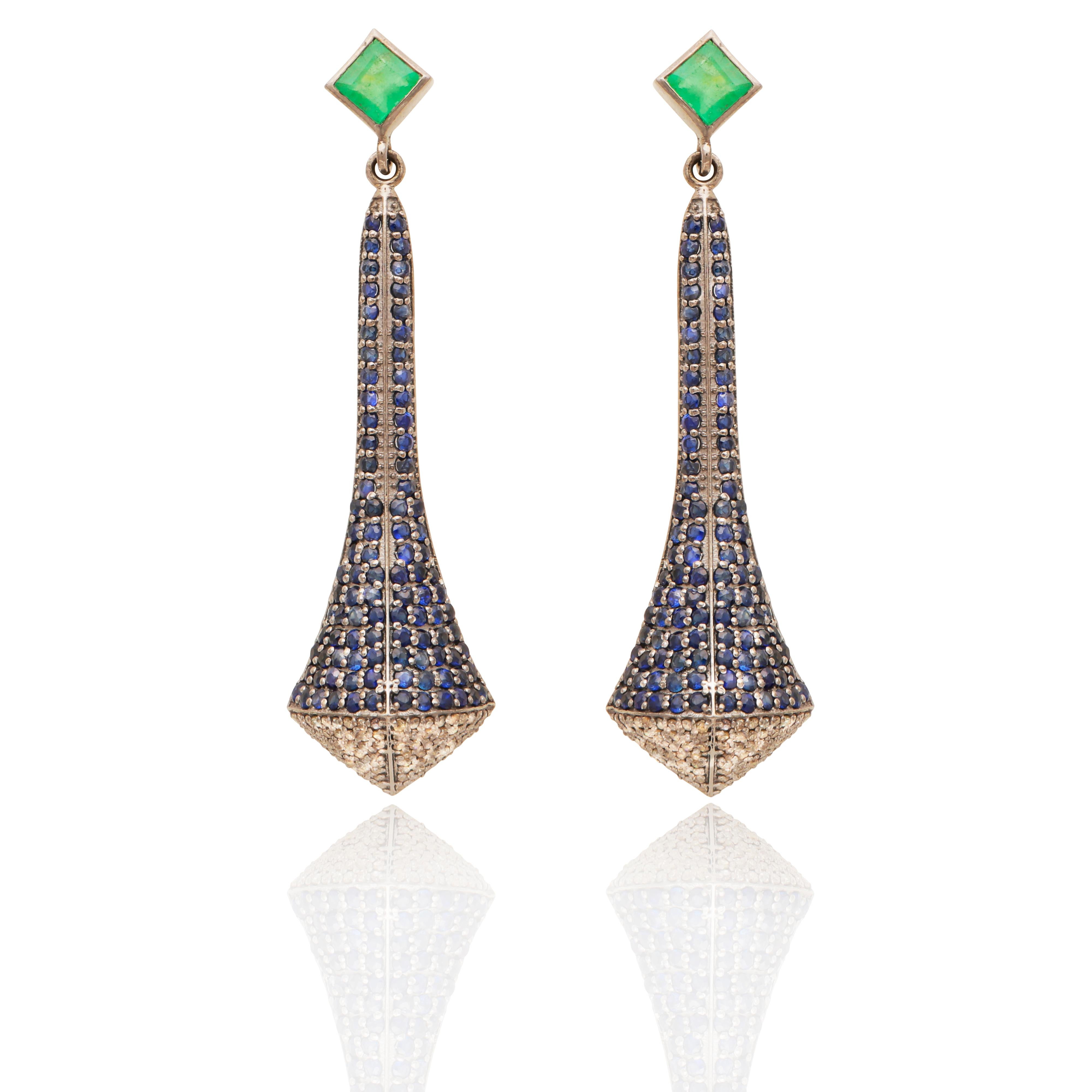 An Art Deco Style pair of earrings set with single cut pave diamonds and emeralds. Set on 925 oxidized silver to give an old feel and ear backs all in 14 kt gold.

1.252 carat sappphire; 0.180 carat emerald; 0.90 grams 14 kt gold; 7.098 grams