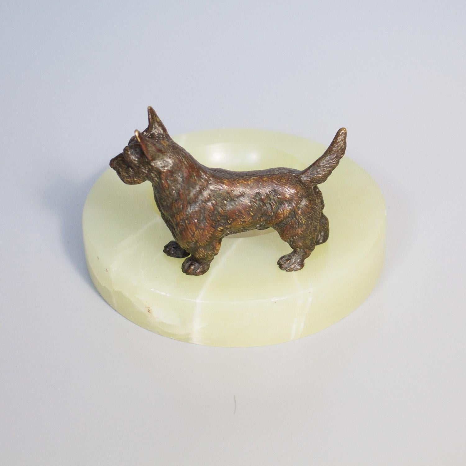 An Art Deco Vide Poche with a solid bronze scottie dog set over green onyx. 

Dimensions: H 7cm, W/D 10.5cm

Origin: English

Date: circa 1930

Item number: 288206.