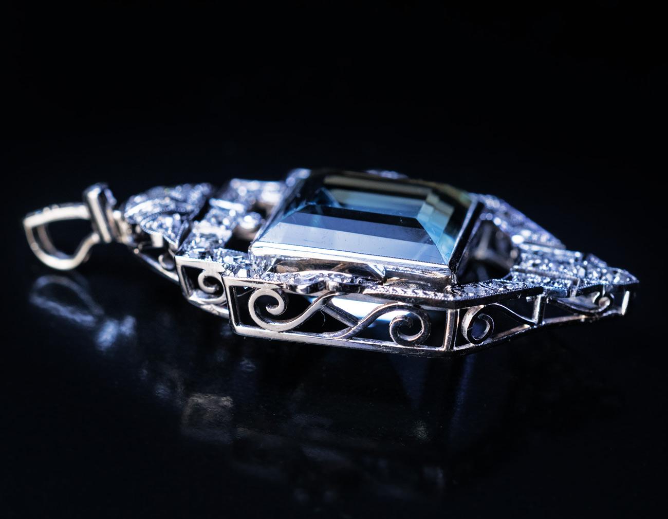 Austria, Vienna, circa 1930

This stylish vintage white 14K gold necklace features an excellent square step cut aquamarine surrounded by an ornate Art Deco geometric frame embellished with diamonds.
The aquamarine measures 14.18 x 14.17 x 10.87 mm
