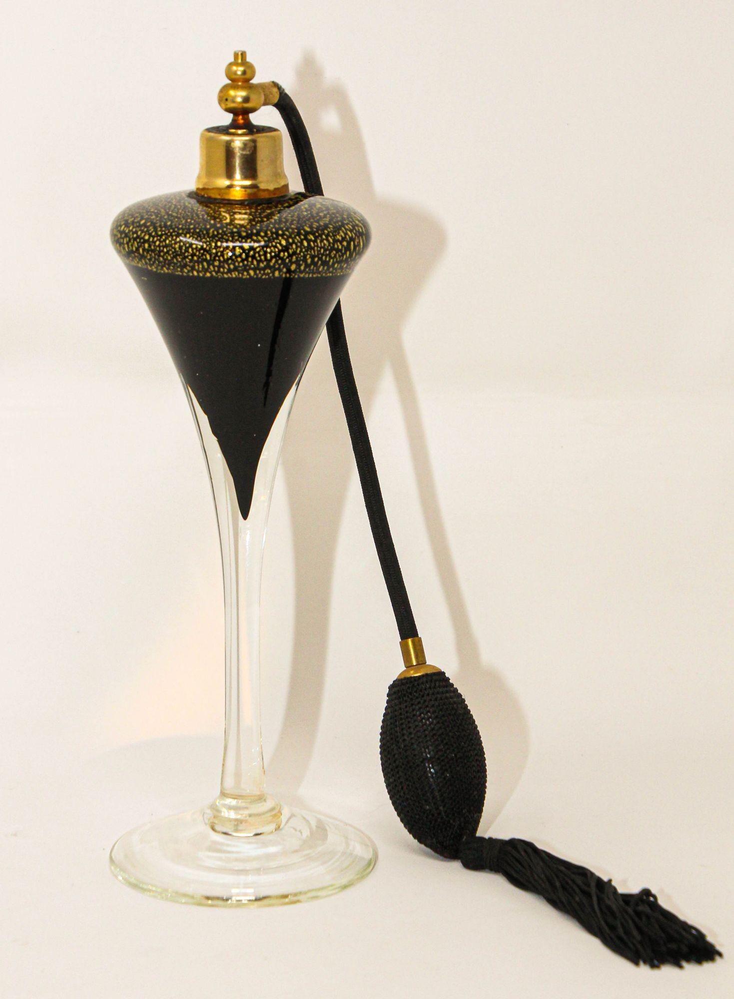Vintage Art Deco style Archimede Seguso tall black and gold aventurine perfume bottle with black silk atomizer.
Italian Murano art glass perfume bottle black glass with sparkling gold aventurine and clear long fluted tulip glass shape. 
This piece