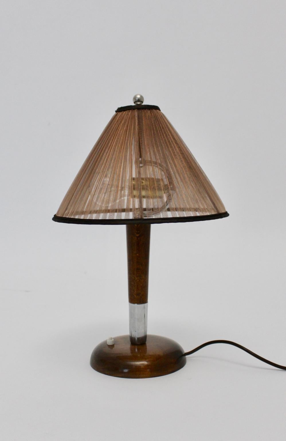 Art Deco Vintage Tischlampe aus Buche und Nickel 1930er Jahre Österreich.
Diese Tischlampe wurde um 1930 entworfen und hergestellt.
Auch der Stiel wurde aus massivem Buchenholz gefertigt, braun gebeizt, lackiert und vernickelt.
Der erneuerte