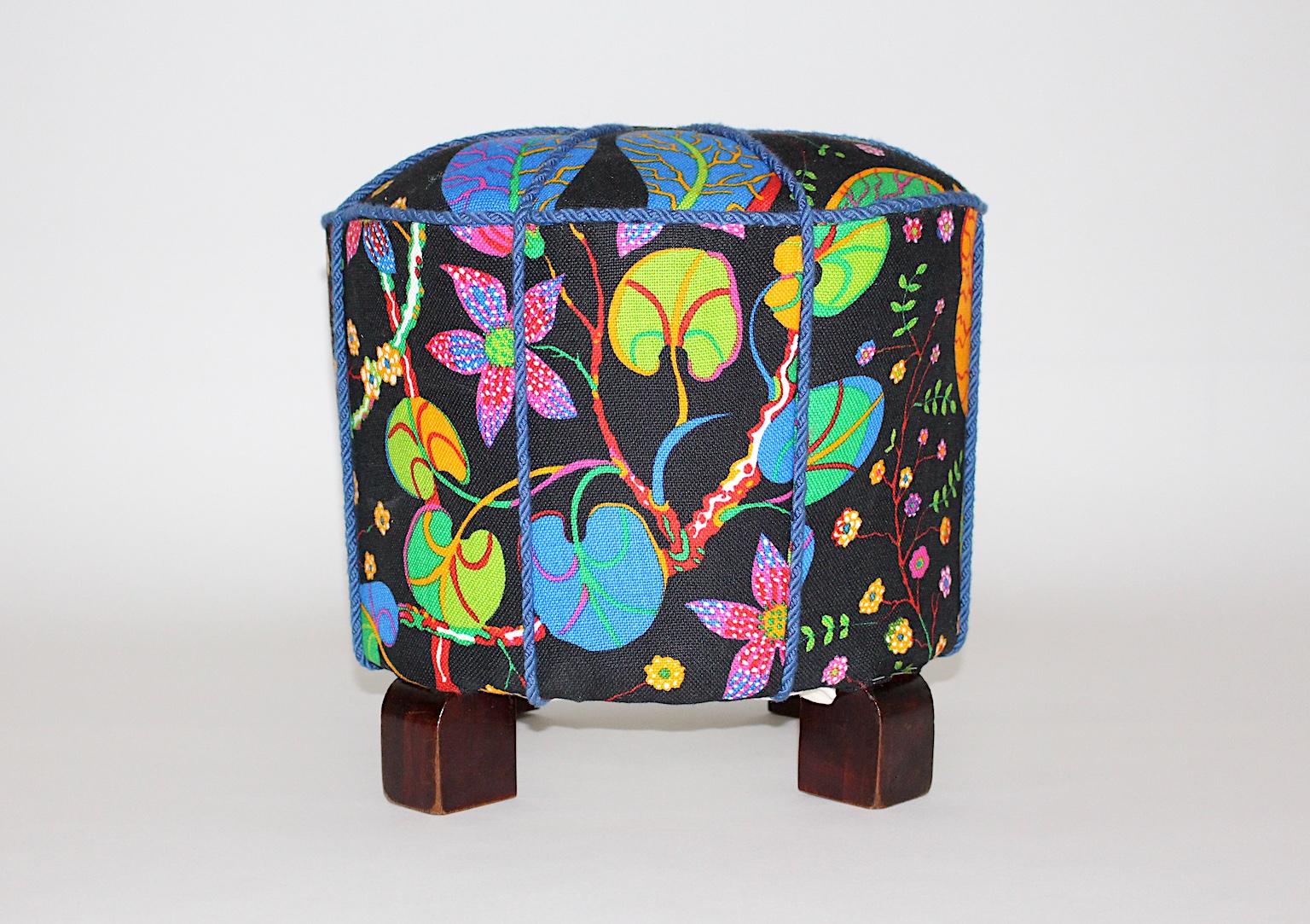 Pouf ou tabouret Art Déco vintage avec pieds en bois de hêtre, qui a été retapissé et recouvert d'un magnifique tissu multicolore. Ce tissu a été conçu dans les années 1930 par Josef Frank et est désormais fabriqué par Svenskt Tenn. Le tissu est