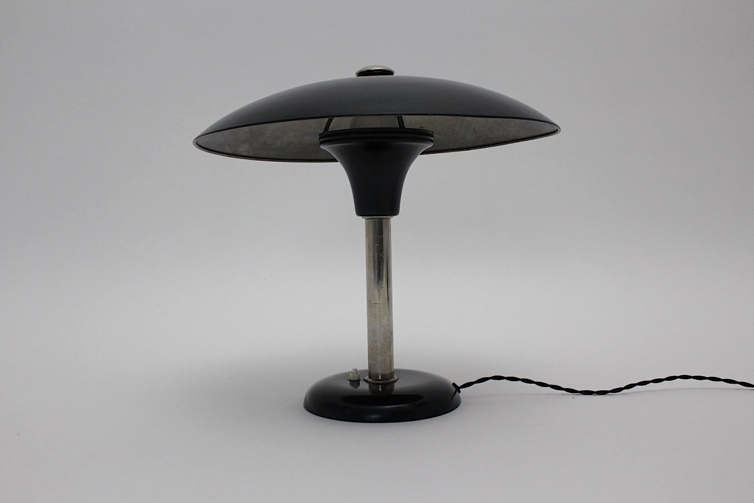 An Art Deco vintage black chrome table lamp or desk lamp designed by Max Schumacher 1934 Germany and executed by Werner Schröder, Lobenstein, Germany.
The black lacquered metal table lamp shows a beautiful shade like a mushroom with a chromed stem