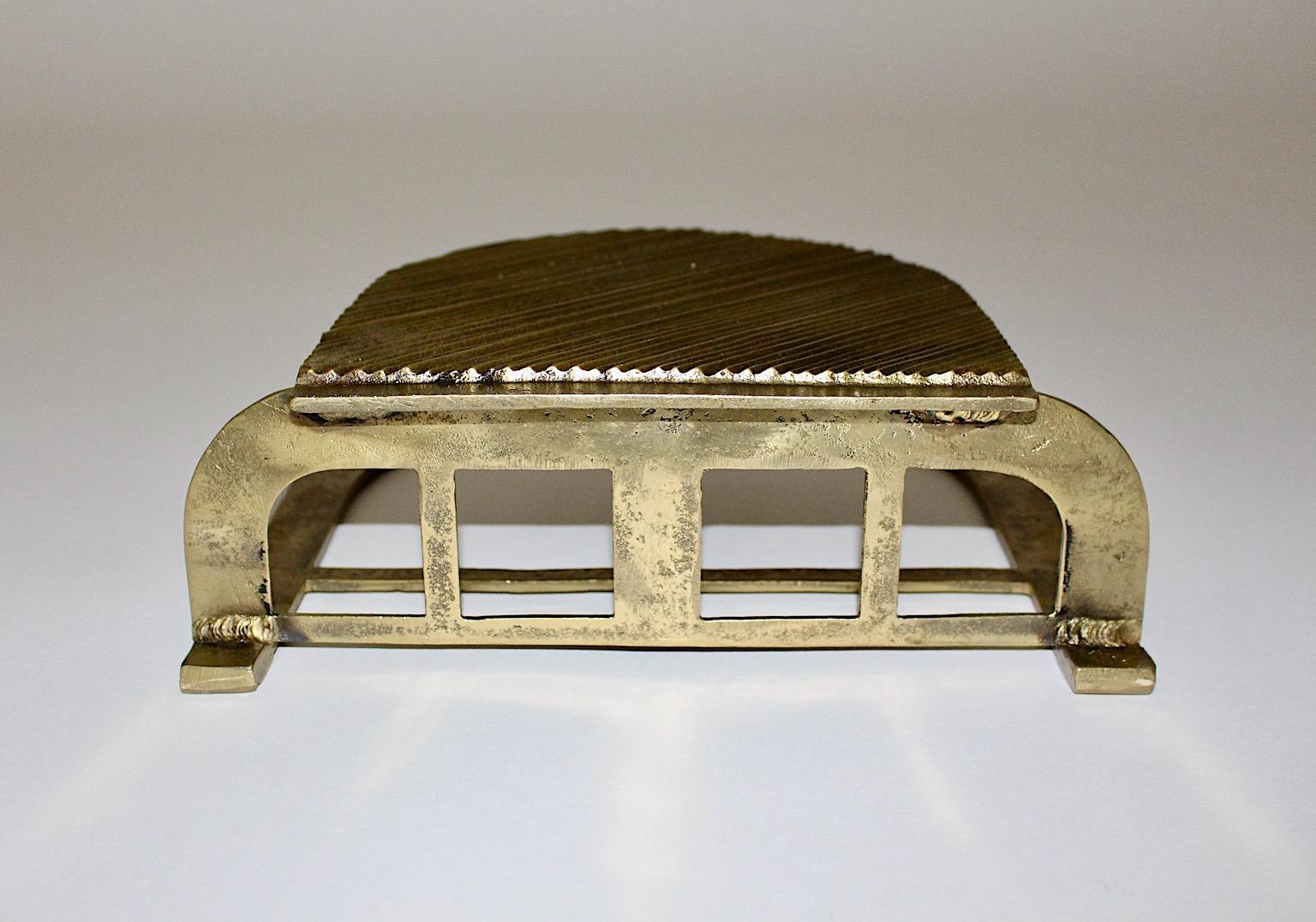 Art Deco vintage newspaper rack or magazine rack from solid brass circa 1900 - 1920, Austria.
While the front of the newspaper rack features a grooved front, the base shows squared pattern and the back flows into a round arch.
Could be paired as a