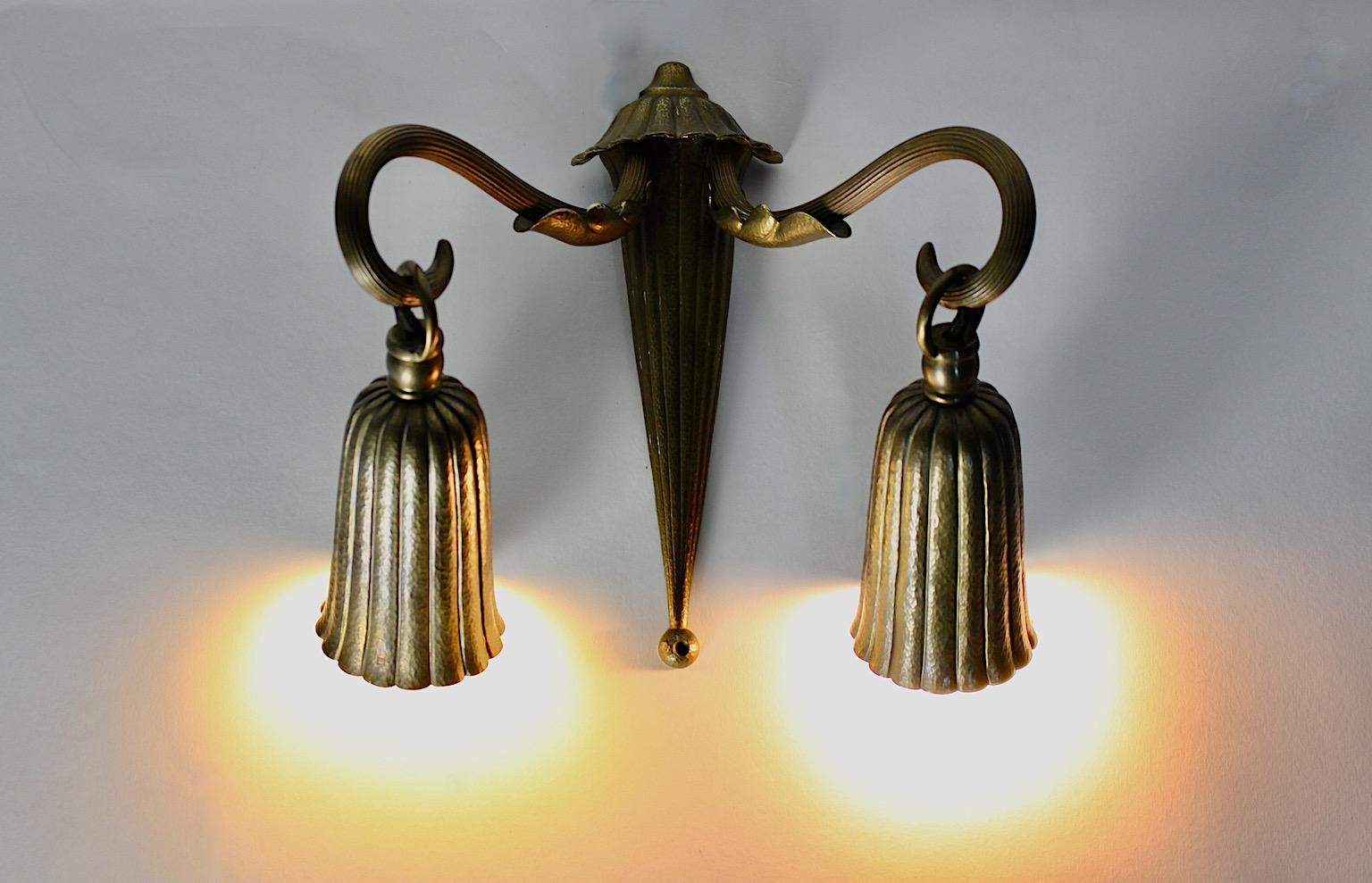 Art Deco vintage brass sconce or wall lighting bell like 1930s Austria.
An amazing sconce or wall light from hammered brass with bell like shades in charming shape.
This sconce features wonderful details as conical slightly tapered stem and bell