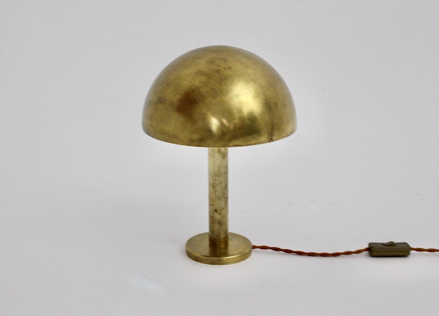 Art Deco vintage table lamp from brass mushroom like designed and manufactured in Austria, 1930s.
The table lamp shows a beautiful dome shade with a circular stem on a round metal base for a firm and safely stand.
The warm golden tone from the