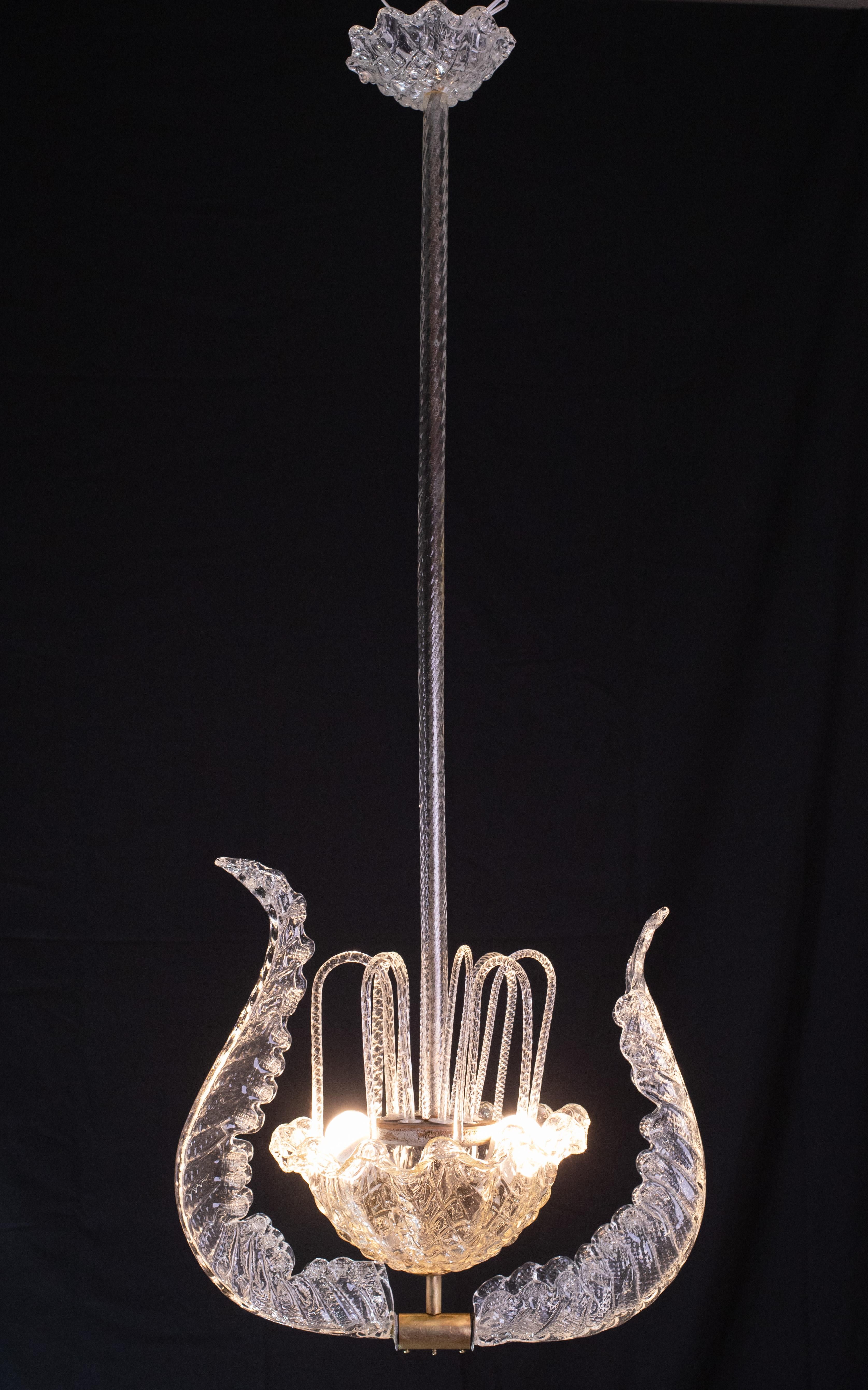 Elegant chandelier attributed to the Barovier and Toso glassworks.

Design period: 1930\1950.

The chandelier consists of a long central element, a glass bowl decorated with two leaves and filled with descending glass.

The two leaves are slightly