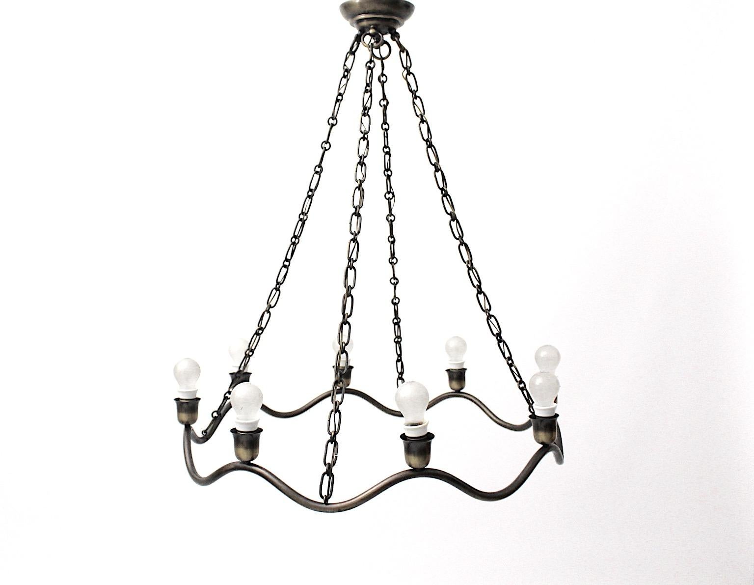 Art Deco vintage brass chandelier in circular shape attributed to Hugo Gorge, circa 1930 Vienna.
A beautiful vintage wavy line chandelier from brass partly blackened impresses through its timeless and plain design.
This sophisticated chandelier