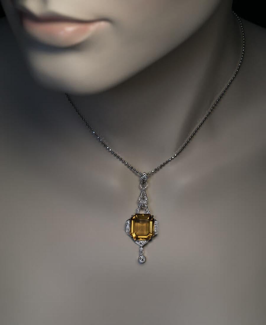 Austria, Vienna, circa 1930

This elegant vintage white 14K gold pendant features an emerald cut golden brown citrine (measuring 13.5 x 12.7 x 7.34 mm, approximately 8.34 ct) set in an ornate Art Deco milgrane frame embellished with bright white