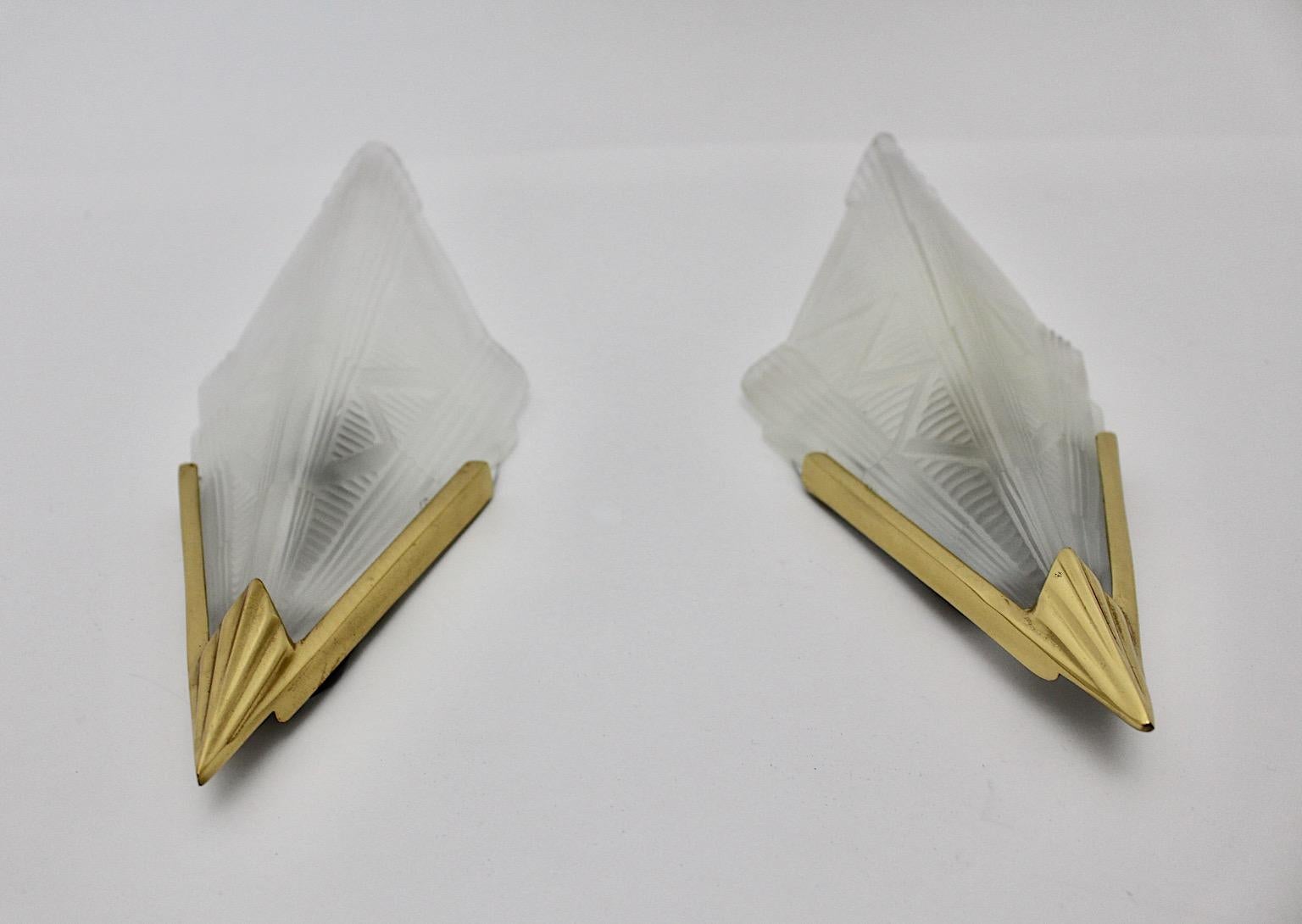 Art Deco-Stil Paar Wandleuchten oder Wandleuchter in Dreiecksform aus Milchglas, Messing, Metall und Kunststoff Degue-Stil, 1990er Jahre, Schweden.
Ein wunderschönes Paar Wandleuchten mit Schirmen aus mattiertem, gepresstem Milchglas mit