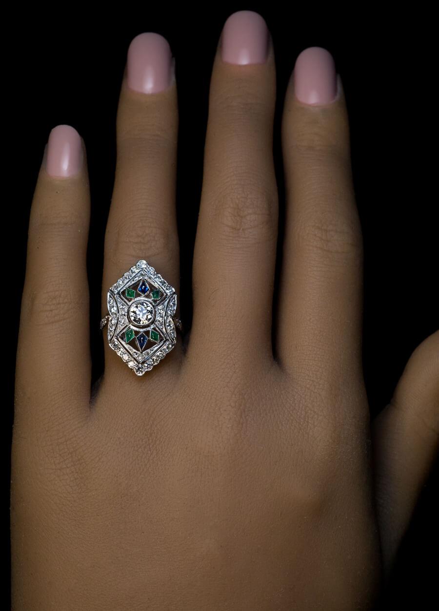 CIRCA 1920er Jahre  Dieser durchbrochene Art-Déco-Ring ist aus Platin gefertigt. Im Mittelpunkt steht ein strahlend weißer Diamant im alten europäischen Schliff (4,8 x 3,1 mm, ca. 0,48 ct, Farbe G, Reinheit SI2), der von kleinen Saphiren und