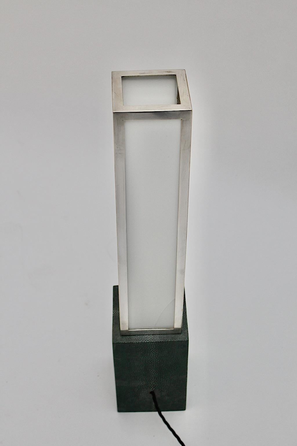 Art Deco Vintage Tischlampe geometrisch aus Plexiglas, vernickeltem Messing und Leder im Stil von Eckart Muthesius 1920er Jahre Deutschland.
Eine wunderbare Art Deco Tischlampe mit einem rechteckigen Sockel aus grünem Leder, während der Lampenschirm