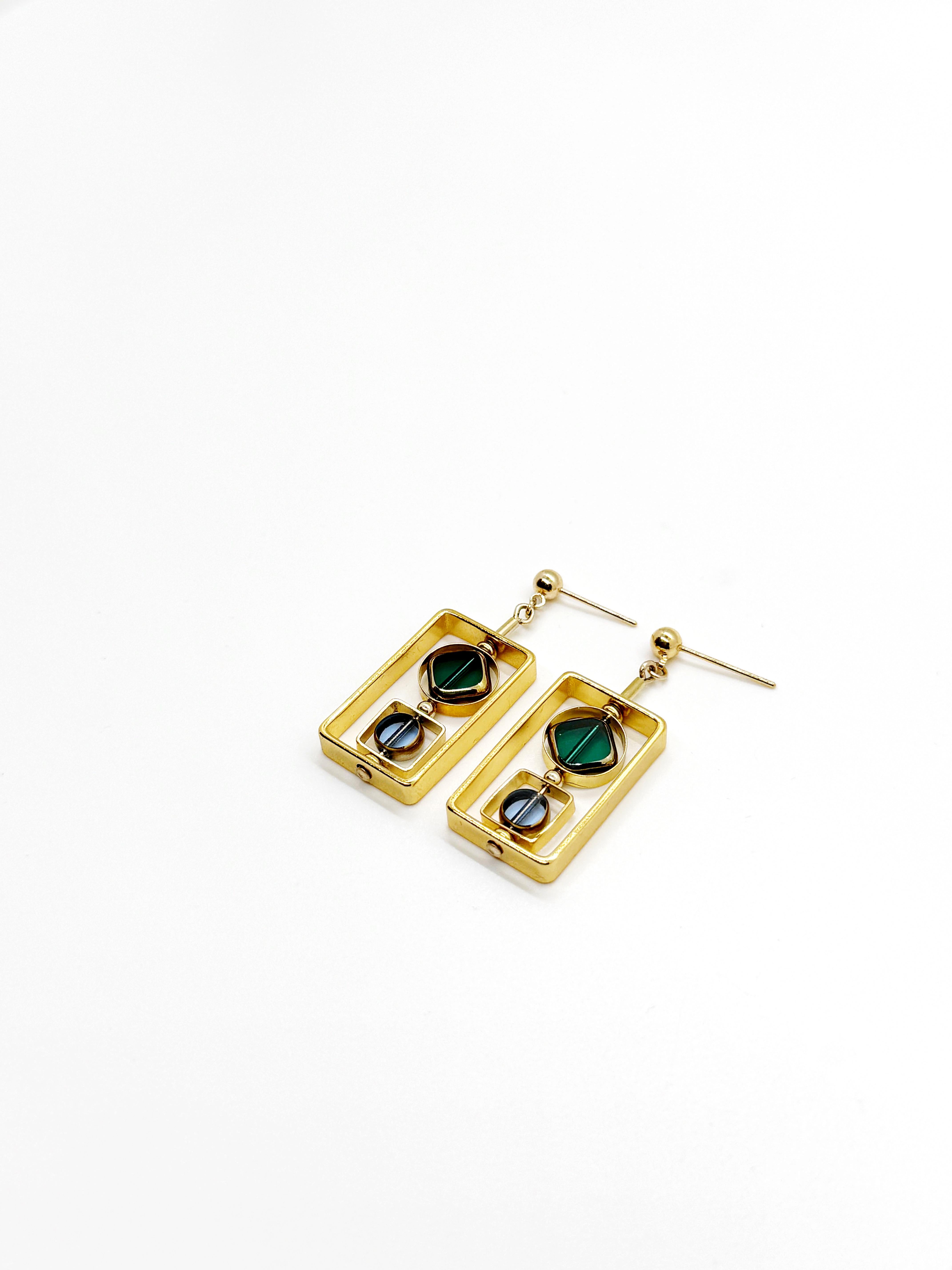 The earrings are lightweight and are made to rotate and reposition with movement. The earrings consist of small translucent blue circle and translucent teal green diamond shaped beads. They are new old stock vintage German glass beads that are