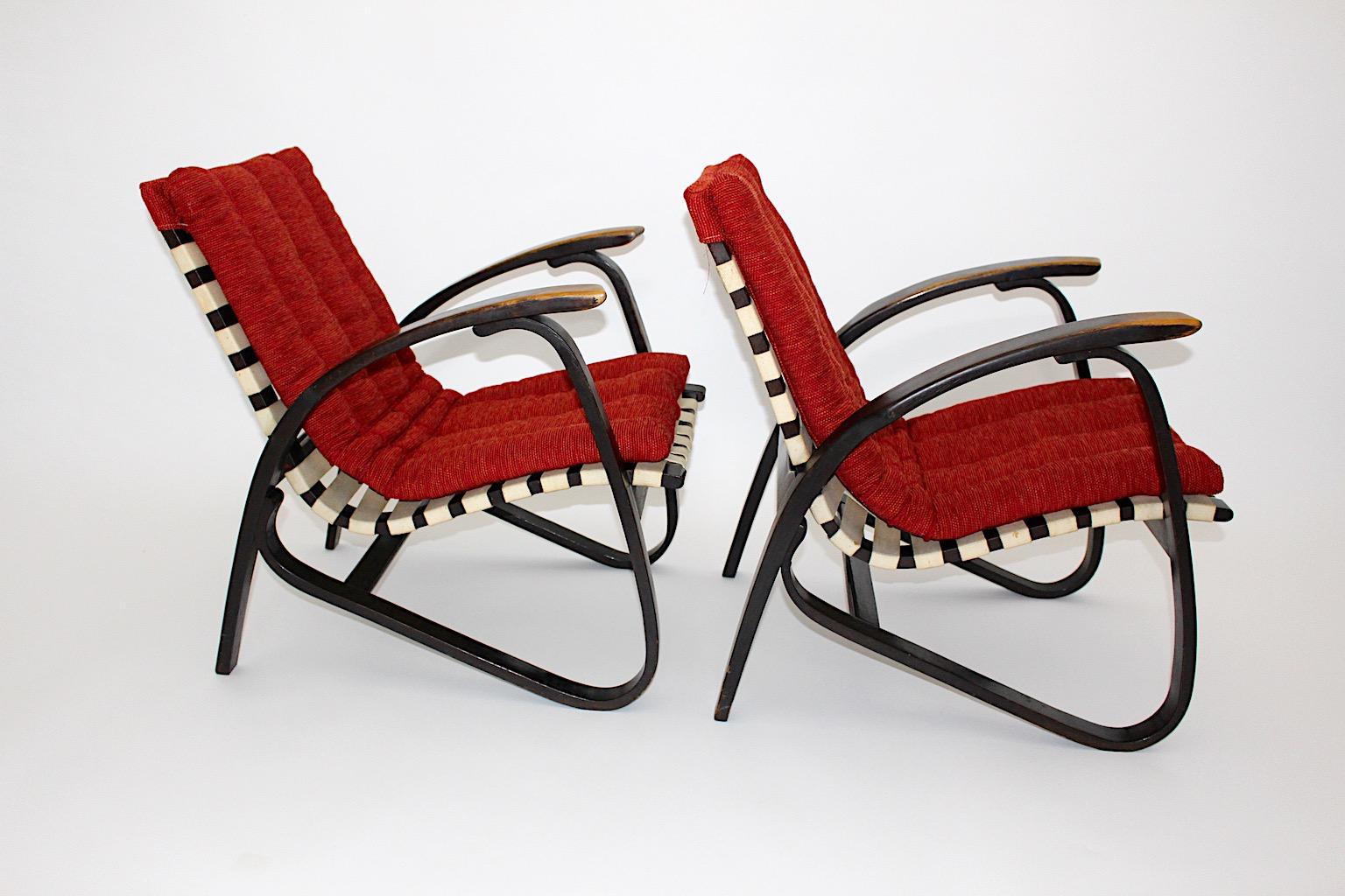 Art Deco vintage lounge chairs pair duo with red upholstery designed by Jan Vanek (1891 - 1962, Czech Rep.) and produced by UP Závody.
An amazing freestanding pair of lounge chairs from bentwood with structured textile loose cover in warm red color.