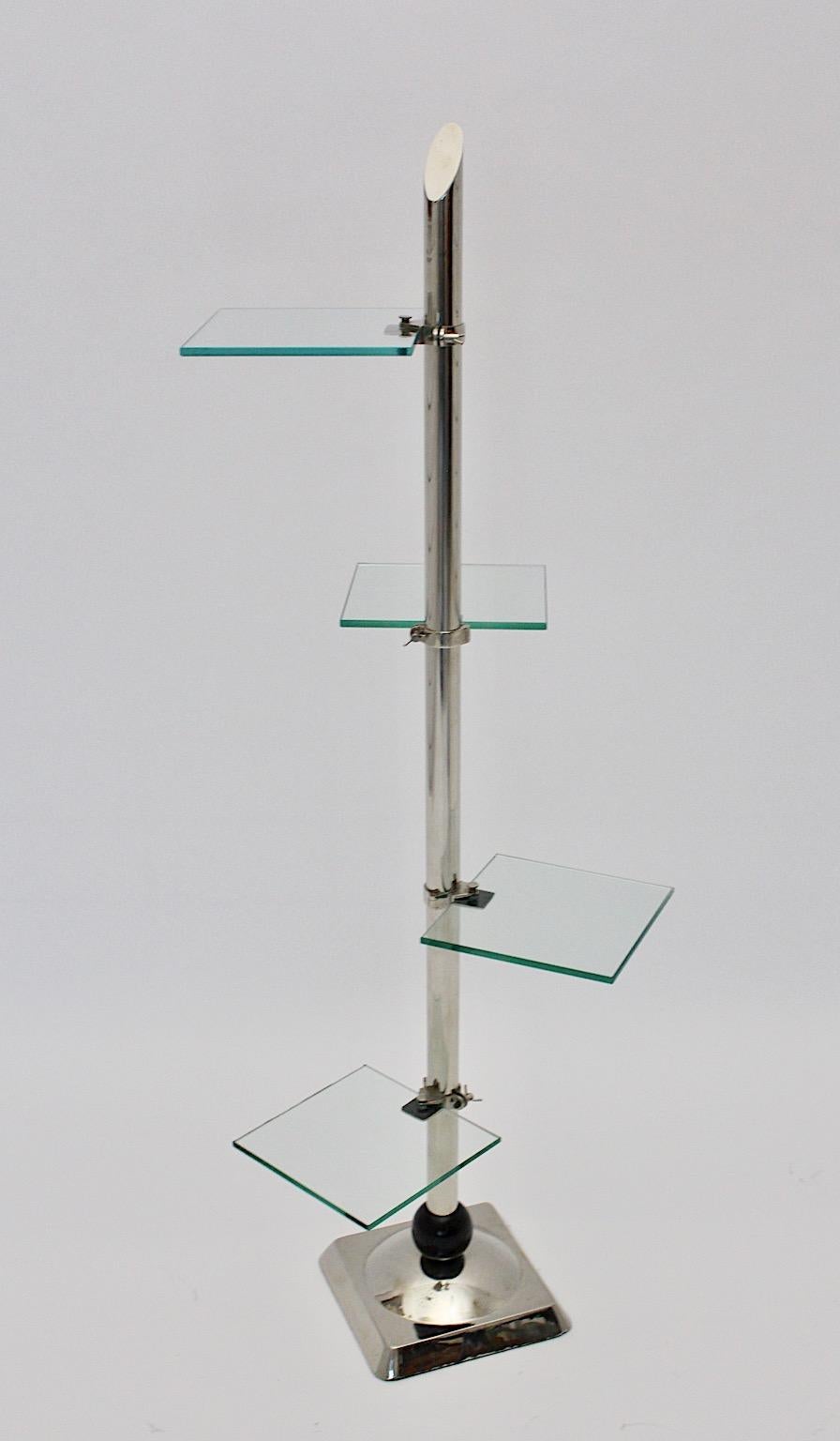 Art Deco vintage flower stand from nickel plated metal and glass, Germany 1930s.
An outstanding and sophisticated Art Deco nickel plated flower stand with four glass shelves shows a nickel plated base with a black wooden ball and a stem with four