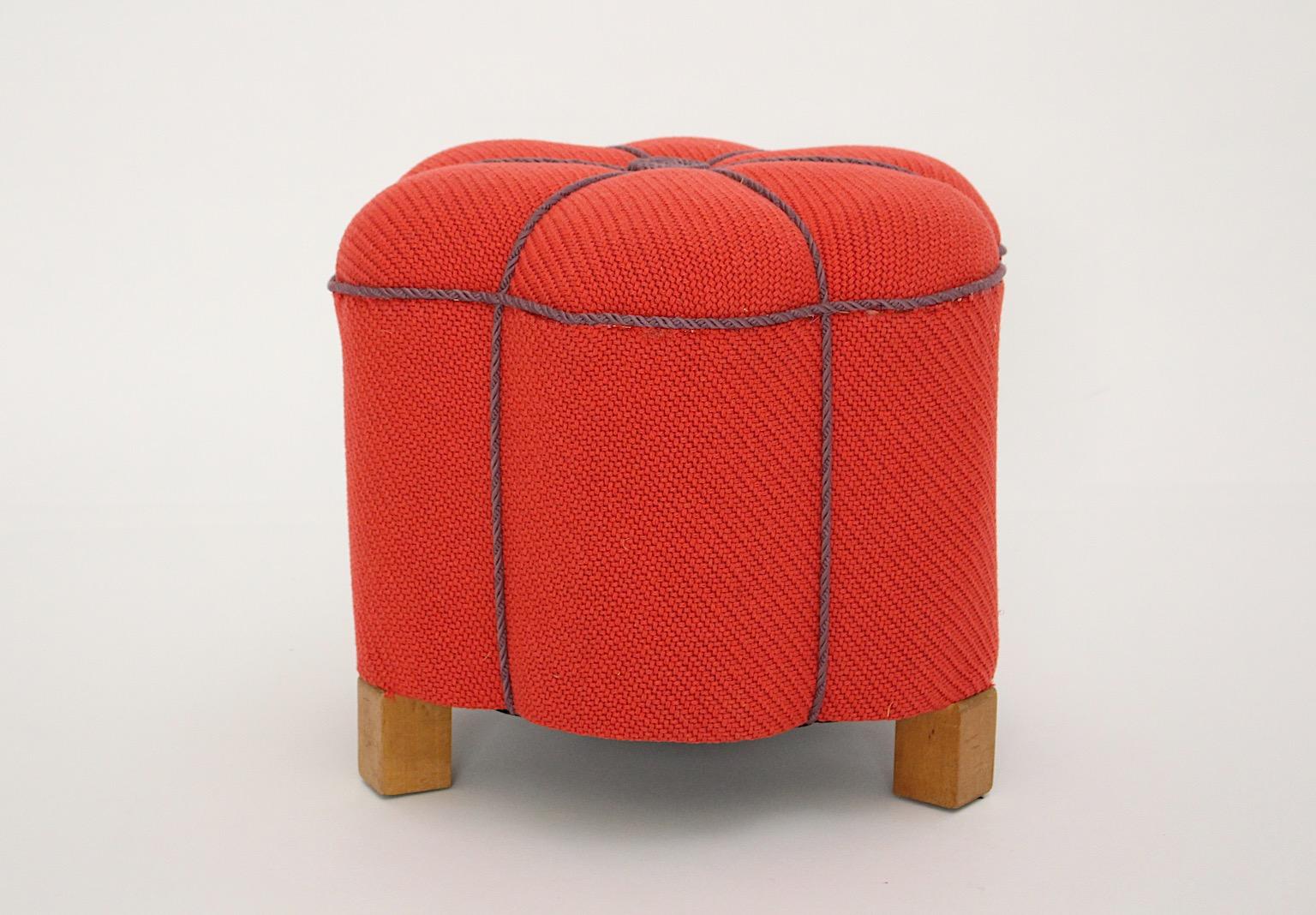 Tabouret ottoman pouf vintage Art Deco en tissu rouge corail et cordes lavande conçu et fabriqué en Autriche dans les années 1930.
Un tissu texturé de haute qualité présente une couleur rouge semblable à un rouge à lèvres et les cordes lavande