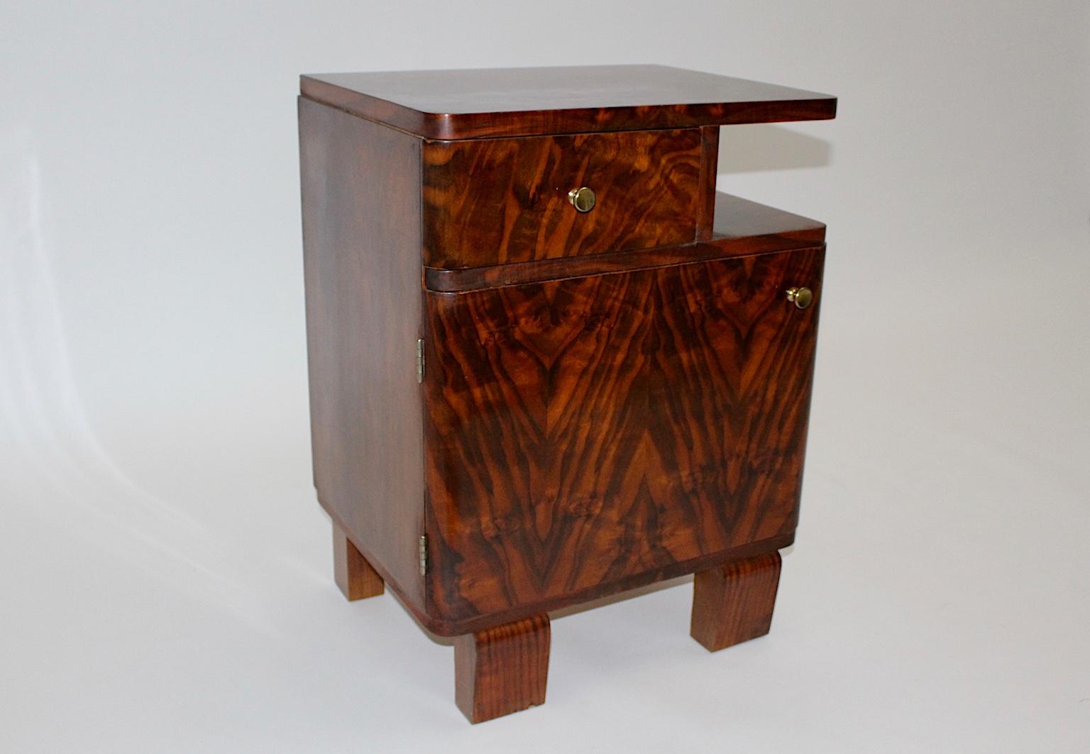 Art Deco Vintage walnut small chest or nightstand from walnut and brass  1930s, Austria.
A stunning small chest from walnut veneer, root wood, spruce and brass. 
This Art Deco chest has a useful inner life with one drawer and one door, while the