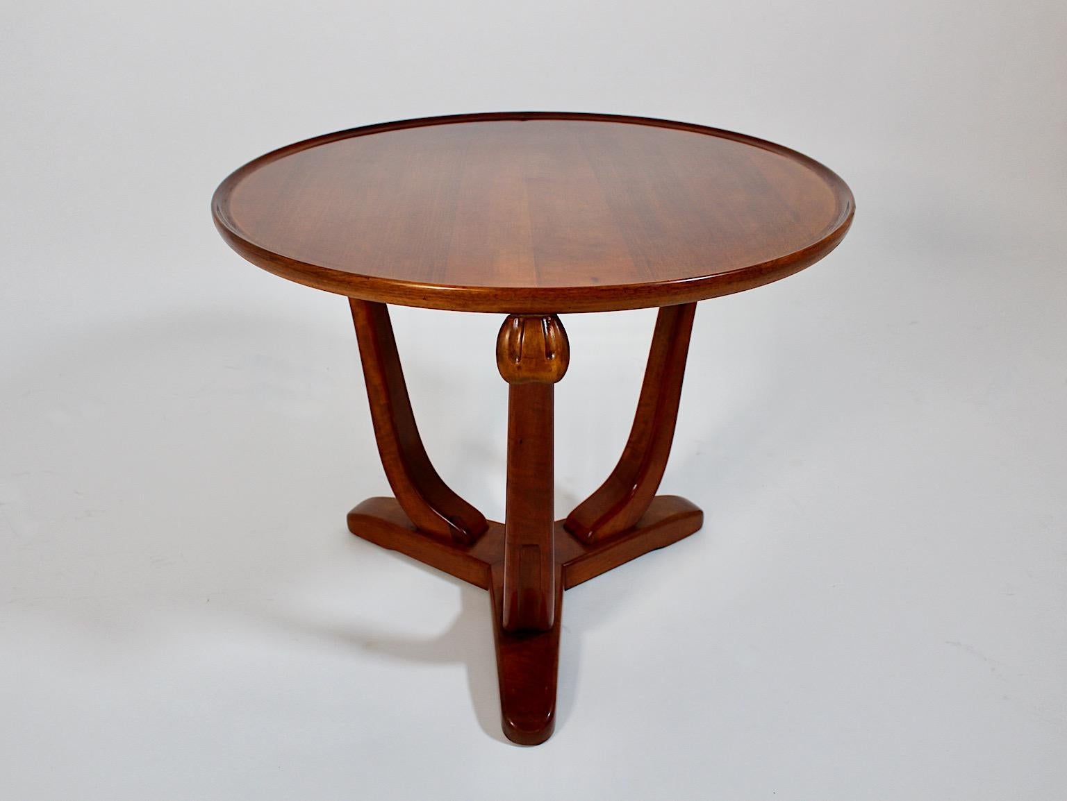 Art Deco vintage circular organic side table from walnut, 1930s, France.
An amazing side table from solid walnut circular like with three slightly curved feet and carved details.
While the feet ends at an organic shaped base, the circular plate
