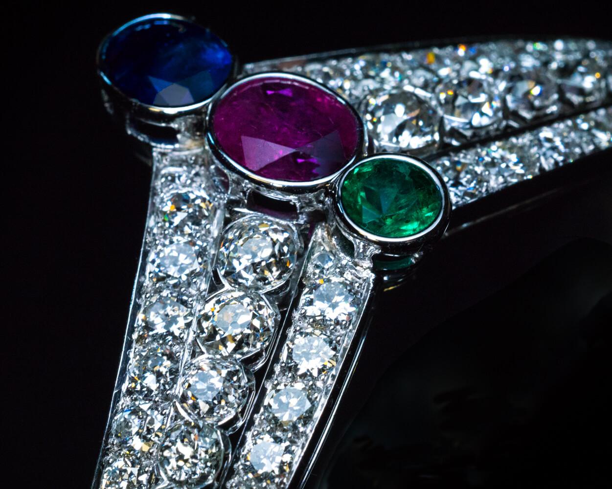 This unique, one of a kind tiara-shaped Art Deco bracelet is finely modeled in 14K white gold. The bracelet is vertically set to the center with a sapphire, a ruby, and an emerald (approximately 1.52 ct, 1.47 ct, 0.48 ct). The colored stones are
