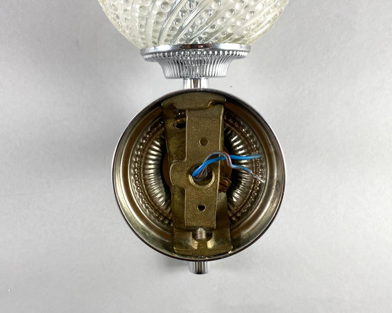 Vintage art deco style wall sconce in chrome plated brass with glass shade creates a perfect combination.

The round lampshade is made of thick transparent glass with tiny bubbles.

There are original plugs for wall mounting on the back.

To
