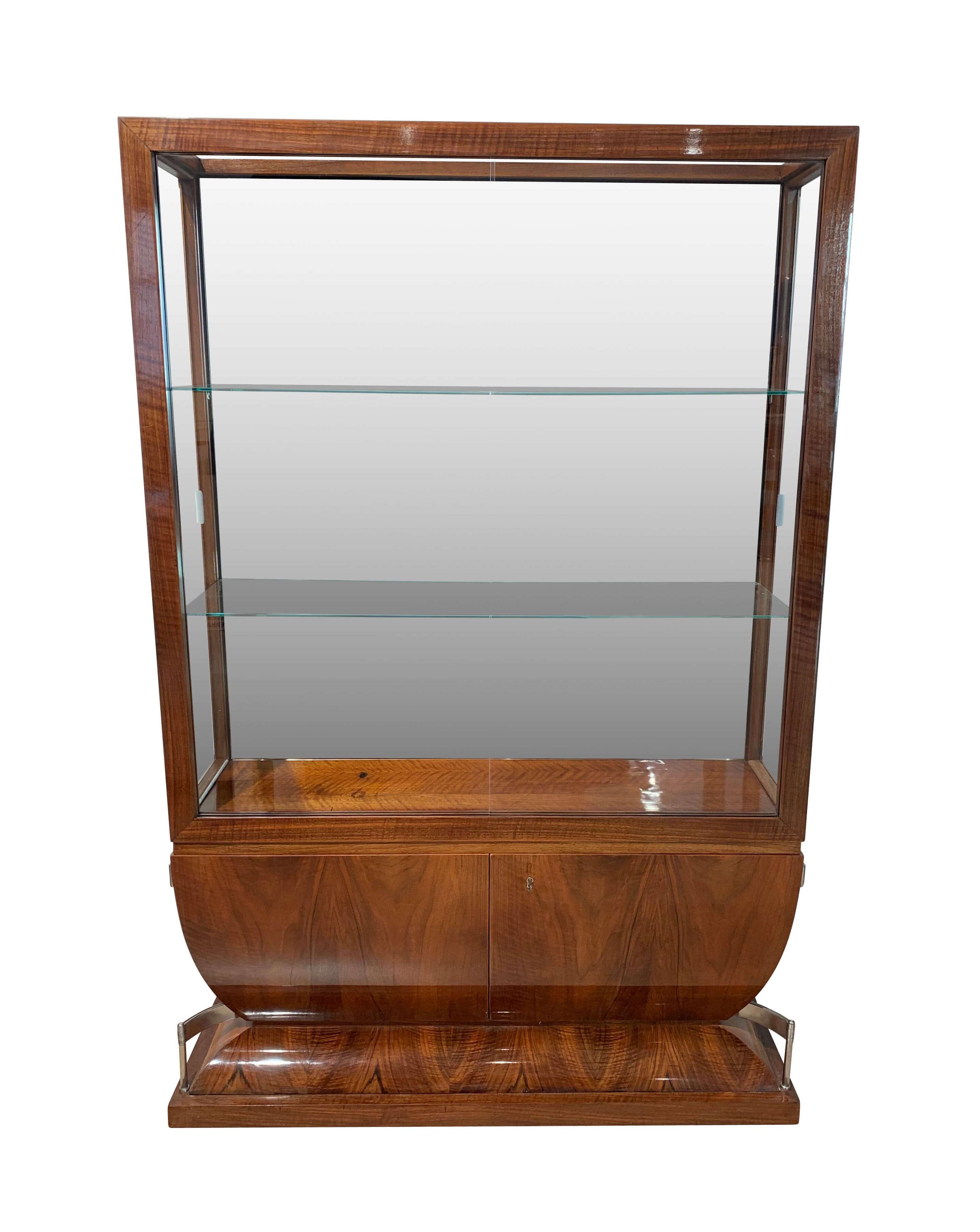 Three-sides glassed Art Deco Vitrine / showcase art from France, circa 1930

Wonderful walnut veneer, French polished
Walnut frame with the faceted glass widows
Extraordinary hinges on the curved bottom doors. At the front, there are two glass