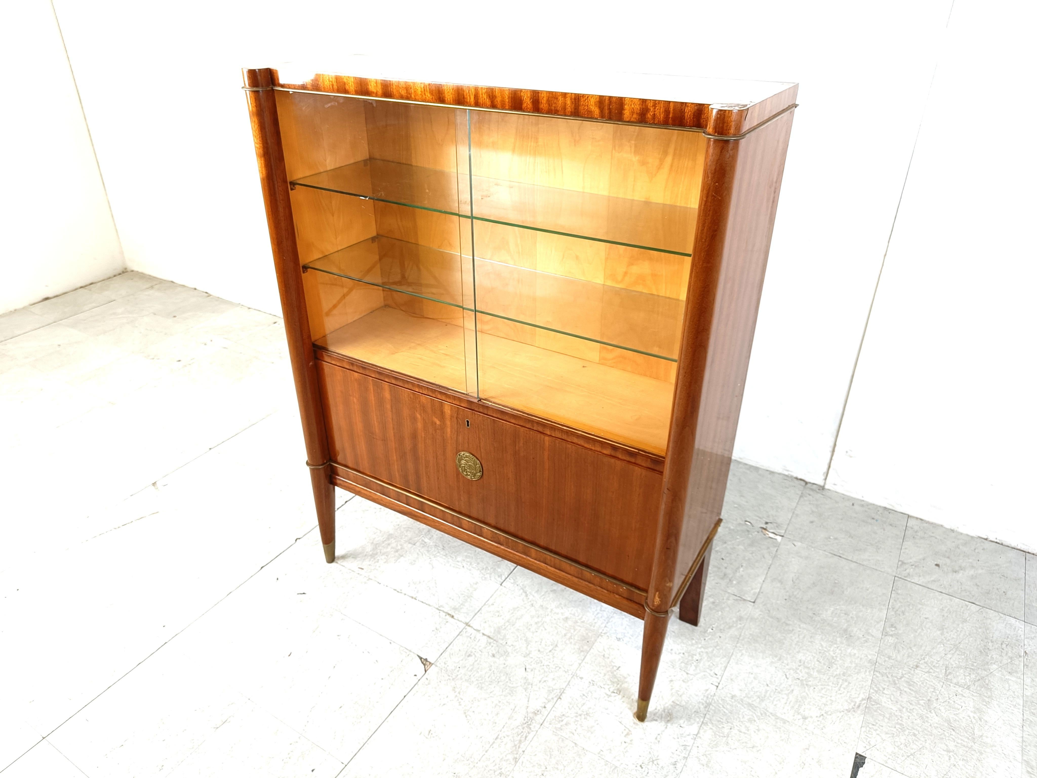 Gorgeous curved art deco cabinet model 'Voltaire' by Decoene Frères in Mahogany, bronze and brass.

Very high quality piece of furniture with an art deco elegance which will contrast beautifully with modern day interiors.

Very good condition.

If