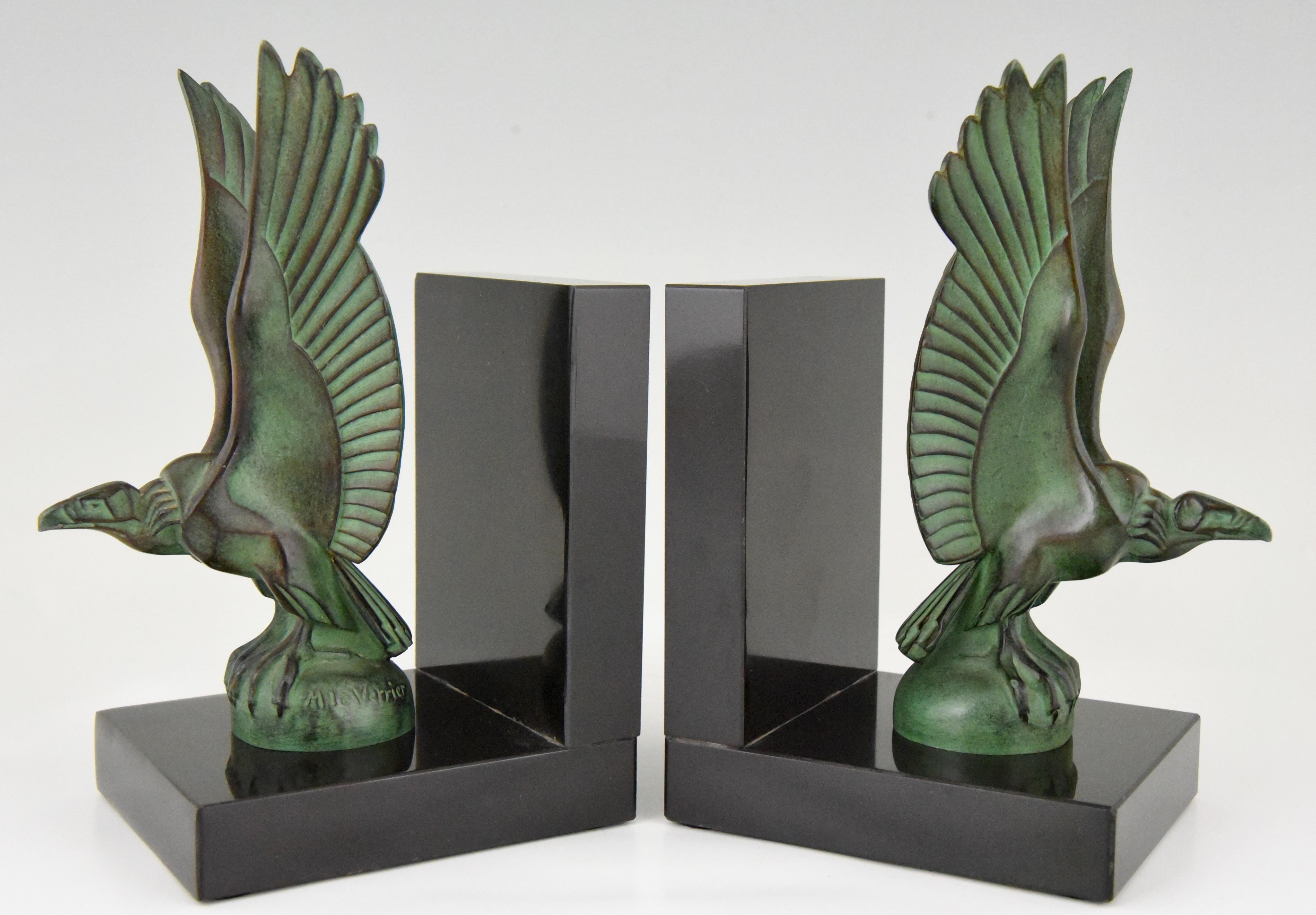 Paire élégante de serre-livres Art Déco avec des oiseaux vautours par Max Le Verrier. Métal d'art à belle patine verte sur socle en marbre noir de Belgique:: France:: vers 1930
Ce modèle est illustré comme mascotte automobile à la page 244