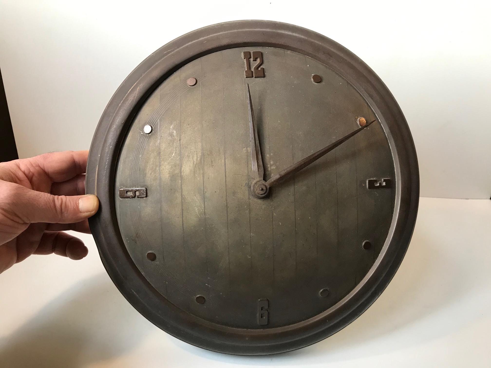 Concave wall clock in brass with pinstripes to the clock face. Due to the concave clock face the hour and minute hand are bend deliberately. It was manufactured in either Germany, Switzerland or France during the 1930s. It has no makers mark or
