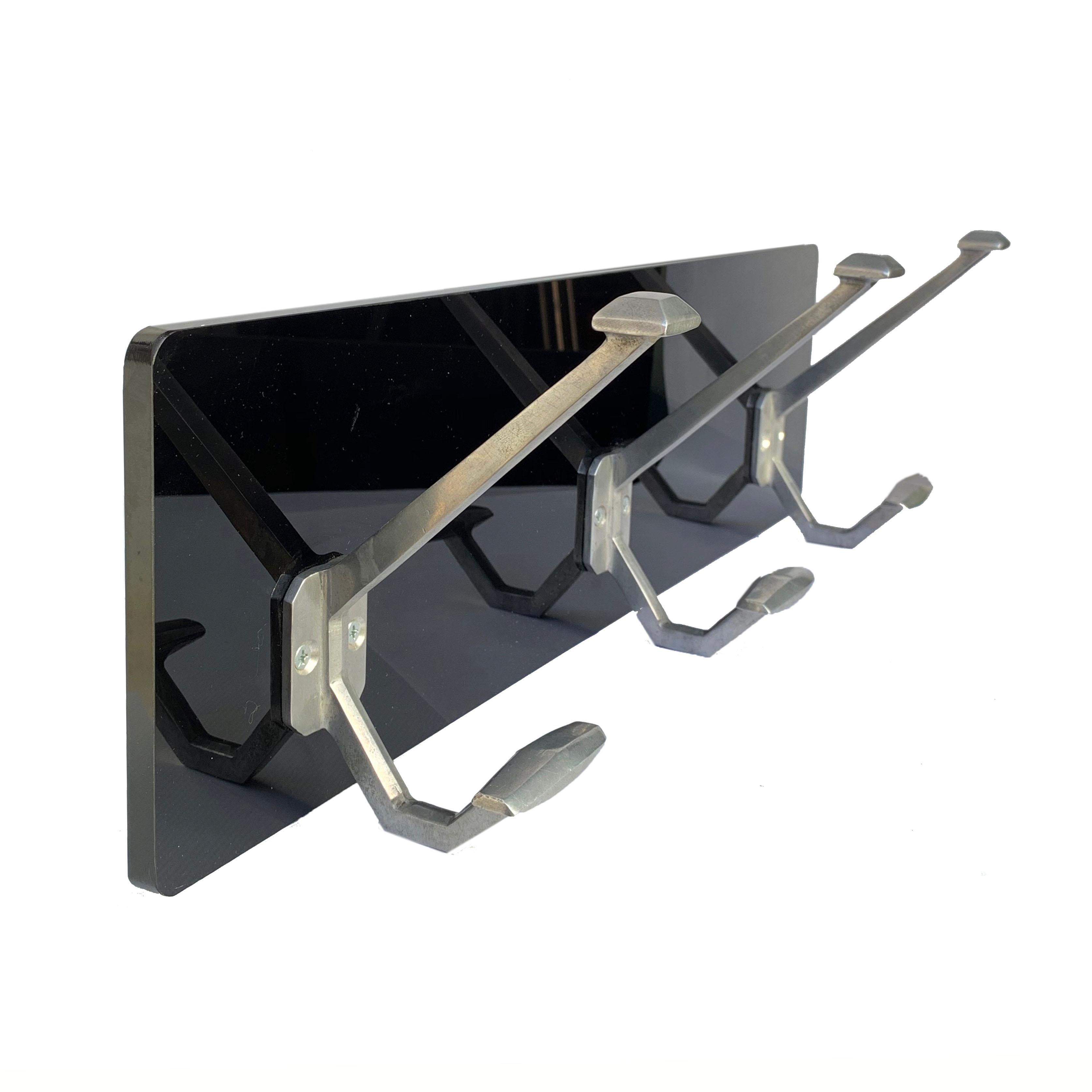 Detail of clothes hangers. The aluminum hooks are from the 1940s, mounted on a new shiny black Plexiglas plate.
  
