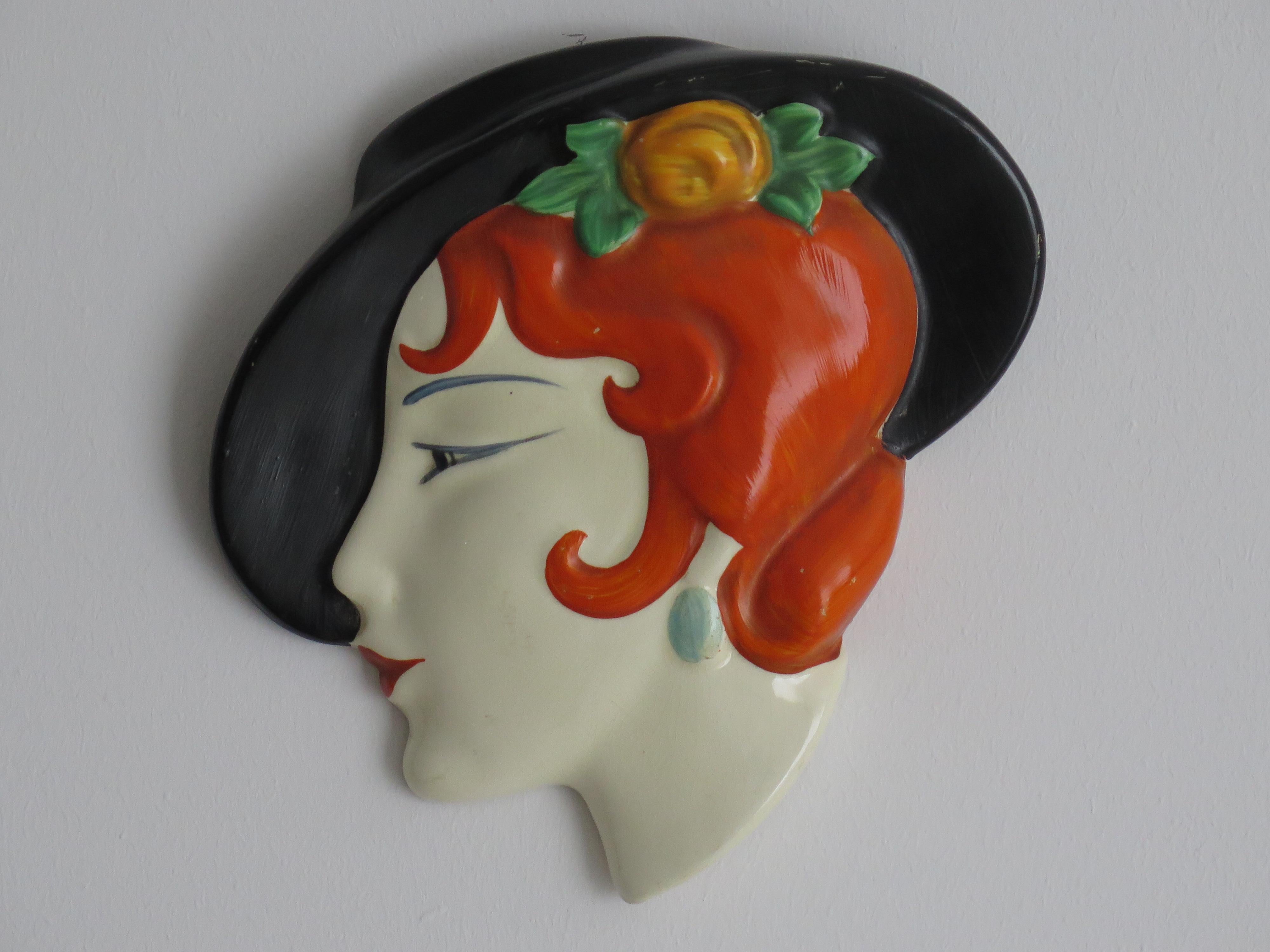 This is an original Art Deco 1930s Ceramic Wall Mask of a Face of a Lady with a Black Hat, made by Lancaster & Sons Pottery of Hanley, Staffordshire, England.

The piece is well potted of earthenware pottery

The mask is beautifully hand painted