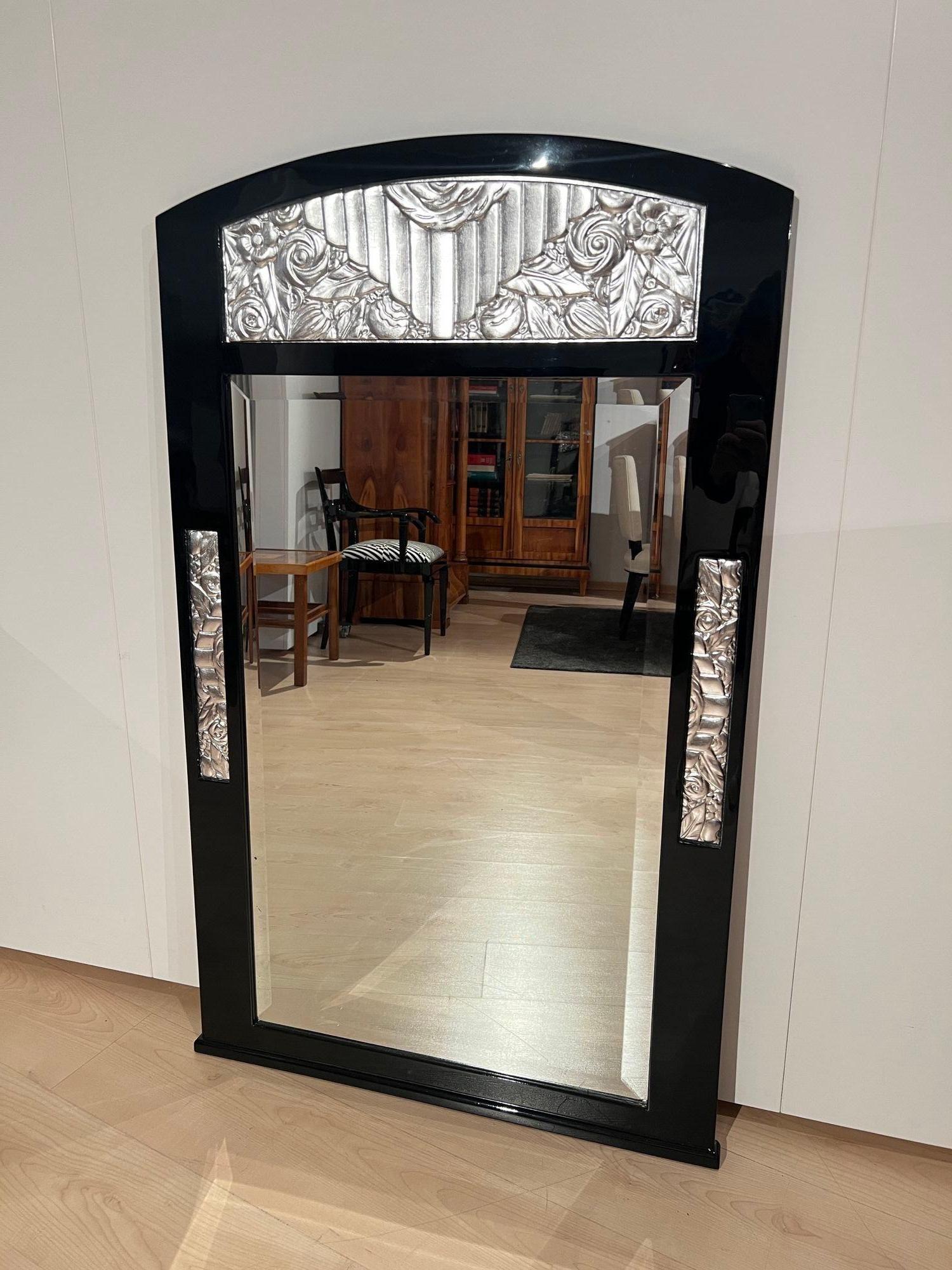 Bellissimo specchio da parete originale in stile Art&Deco proveniente dalla Francia intorno al 1930.
Legno di betulla laccato nero, lucidato a specchio. Ornamenti floreali placcati in argento sui lati e sulla cornice.
Ottimo stato di restauro,