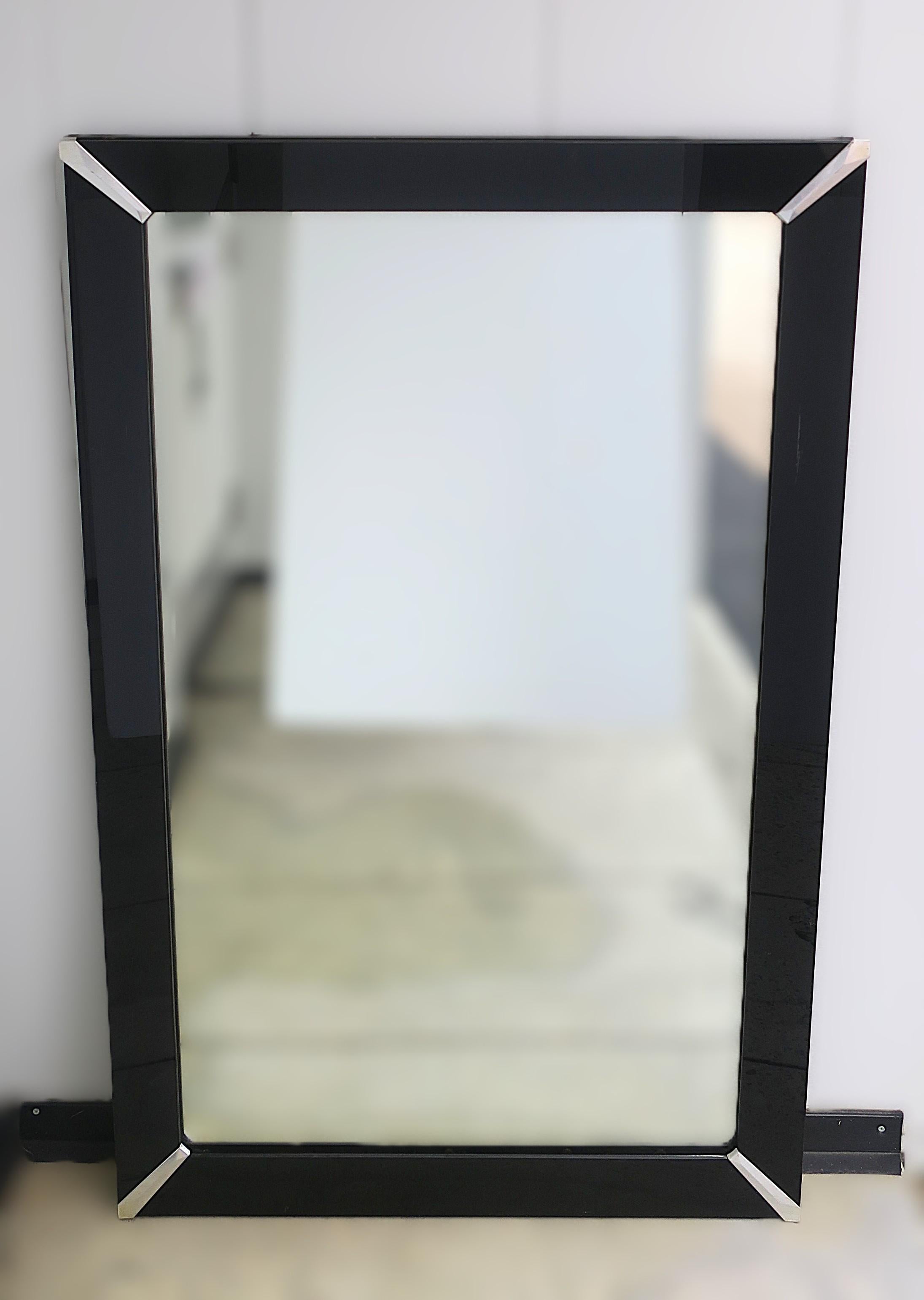 Miroir mural vertical avec cadre en verre noir et coins chromés, période Art Deco, vers le début du 20e siècle, États-Unis. Le miroir est doté d'un cadre en verre noir et d'accents chromés dans les coins. Le miroir est préparé pour être accroché au