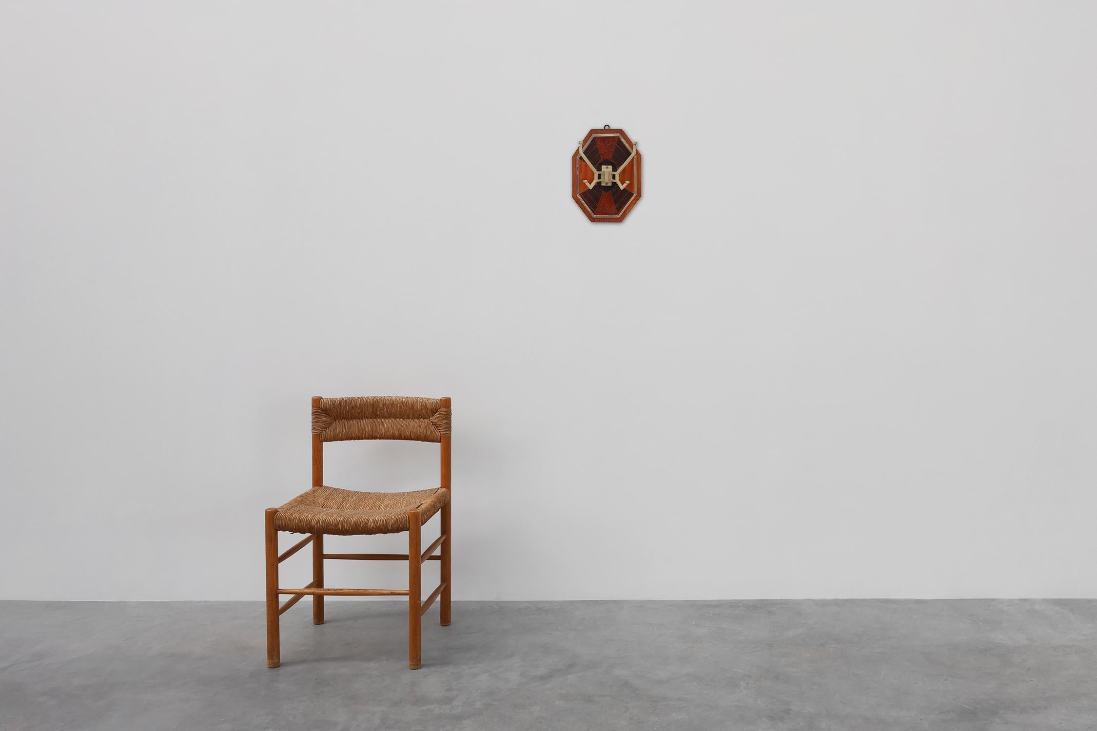 Francia / 1930 / perchero / madera, metal / Art Decó

Perchero de pared con un panel octogonal de madera con un refinado diseño de marquetería geométrica fabricado con chapas de madera en contraste.

La composición resalta la simetría y la precisión