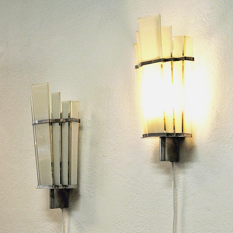 Pair of Art Deco wall sconces with milk glass panels on a metal base and with metal decor bands by manufacturer Zenith, Germany, 1930s-1940s. Marked with Zenith. Gives a pleasant and calming light.
Measures: 35 cm H x 16 cm W x 8 cm D.