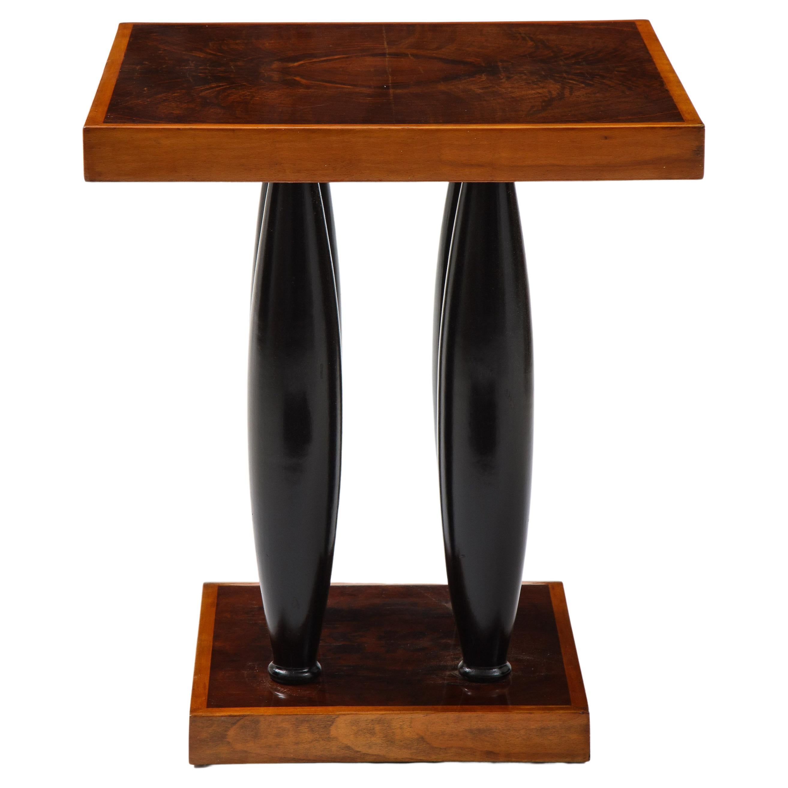 Art Deco walnut side table in the manner of Pierre Legrain featuring a top in walnut with four ebonised columns supports resting on a square base.