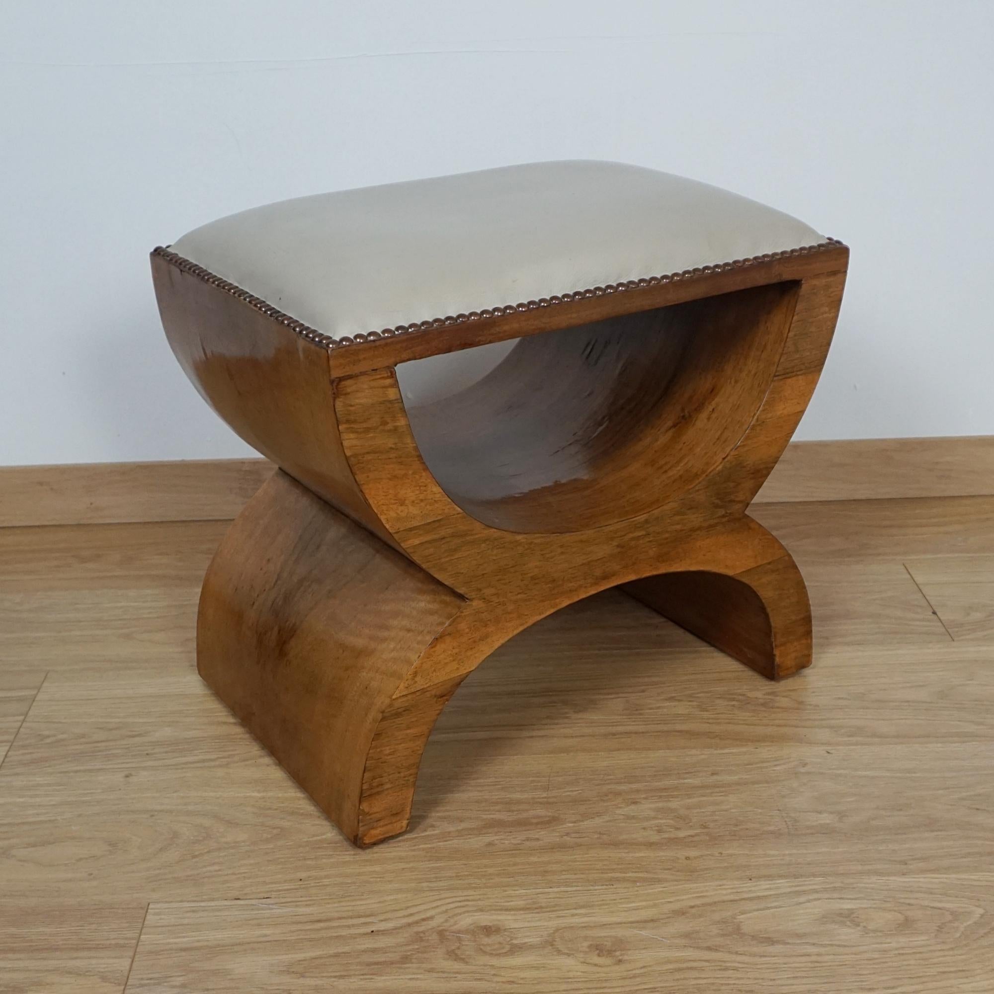 An Art Deco dressing stool. Burr walnut veneered with light grey leather cushion. 

Dimensions: H 46cm W 51.5cm D 36cm