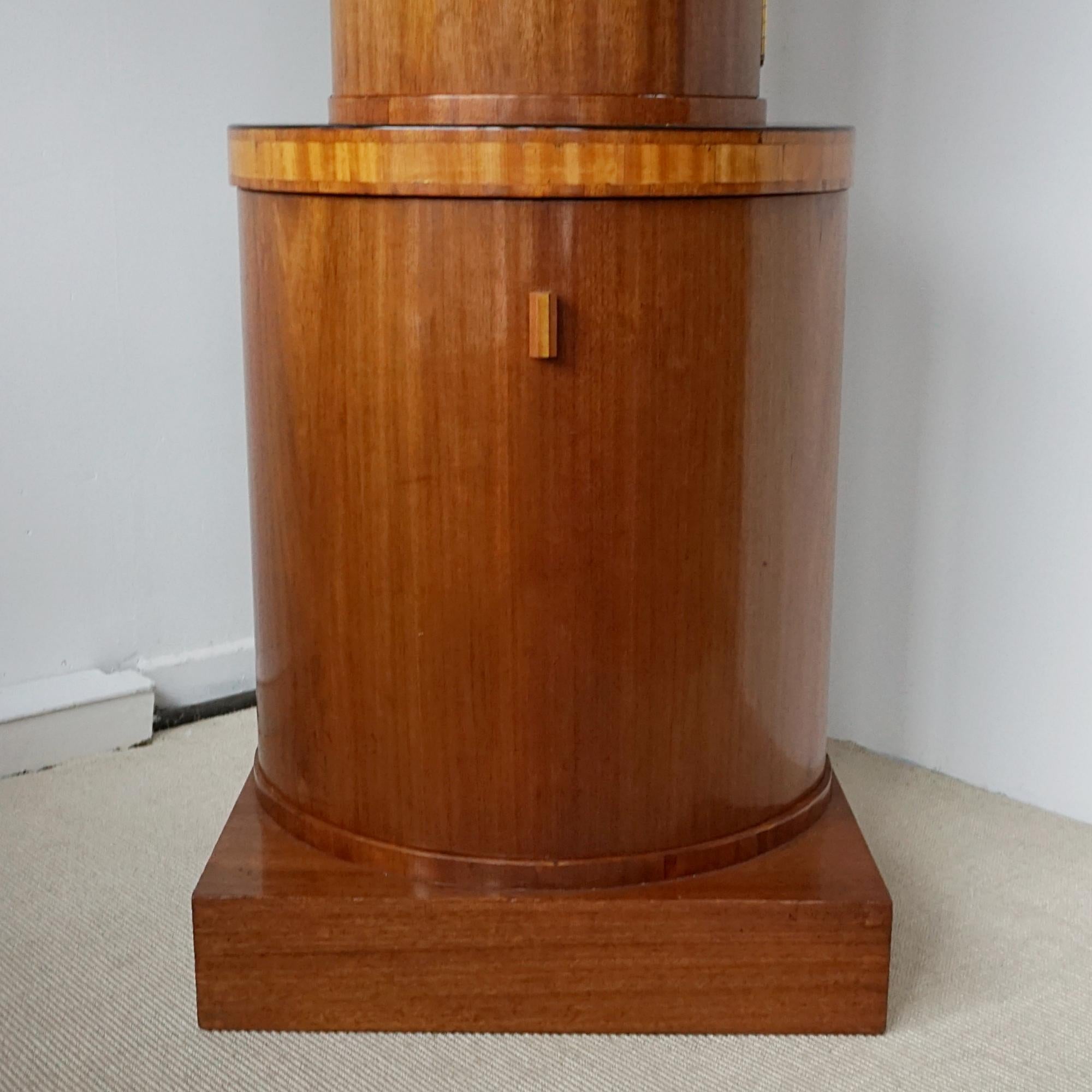 Un mueble de cóctel demi-lune Art Déco. Todo chapado en nogal figurado con bandas de abedul satinado. La sección inferior se abre para revelar un amplio espacio para guardar botellas, con una sección superior interior de espejo para bebidas.
