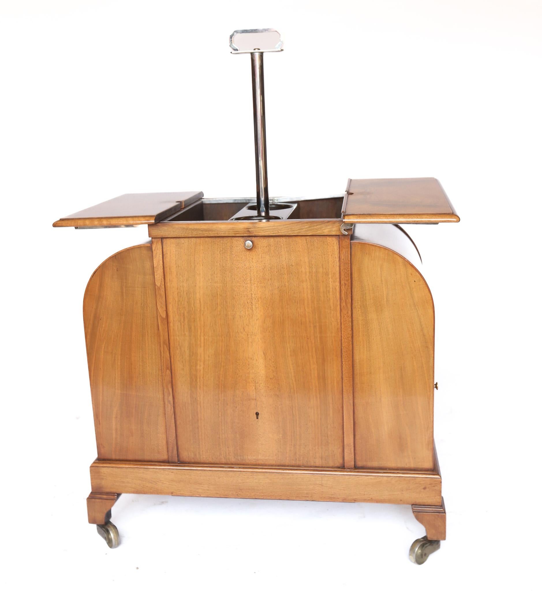 Art Deco Walnut ASPREY  ELevette  Drinks Cabinet circa 1930s
Chrome plated handle on pole, Pulls up, 
The fitted interior to hold bottles,  elevates up
Chrome hinged fittings attach to the top, 
pair of tops each side flip over, to act as table tops