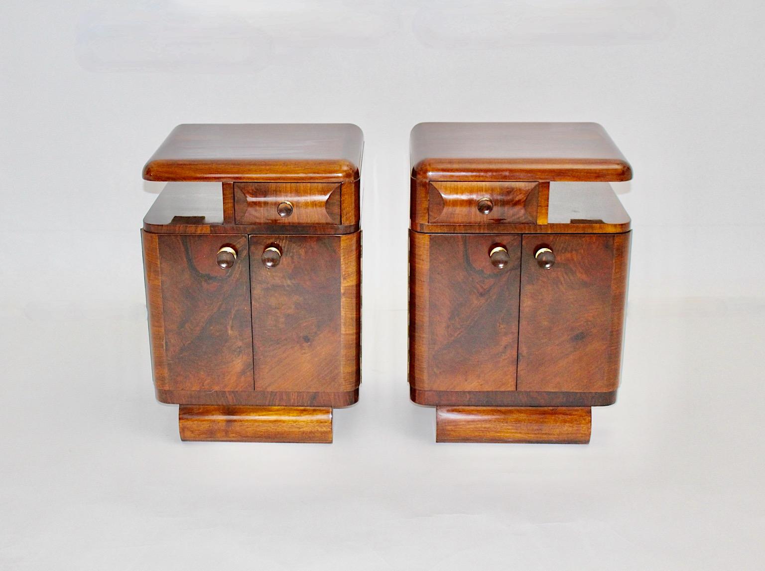 Art Deco vintage walnut and bakelite pair of night stands, which was designed and made out 1930s Austria.
Our pair of Art Deco night stands shows a beautiful walnut veneer and grain, while the round handles were made of bakelite with a brass