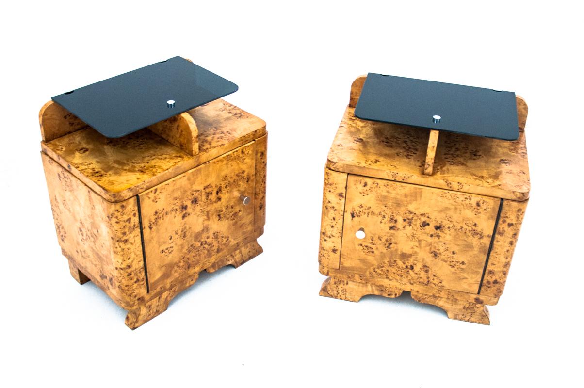 A pair of Art Deco side tables from the Mid-20th Century.
Made of walnut burl and black glass top.
Furniture in very good condition, after professional renovation.

Dimensions: height 56 cm / width 52 cm / depth 34 cm.